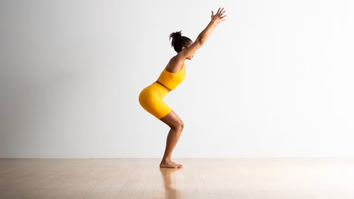 A yoga teacher in Chair Pose