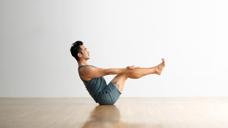 A yoga teacher in Boat Pose