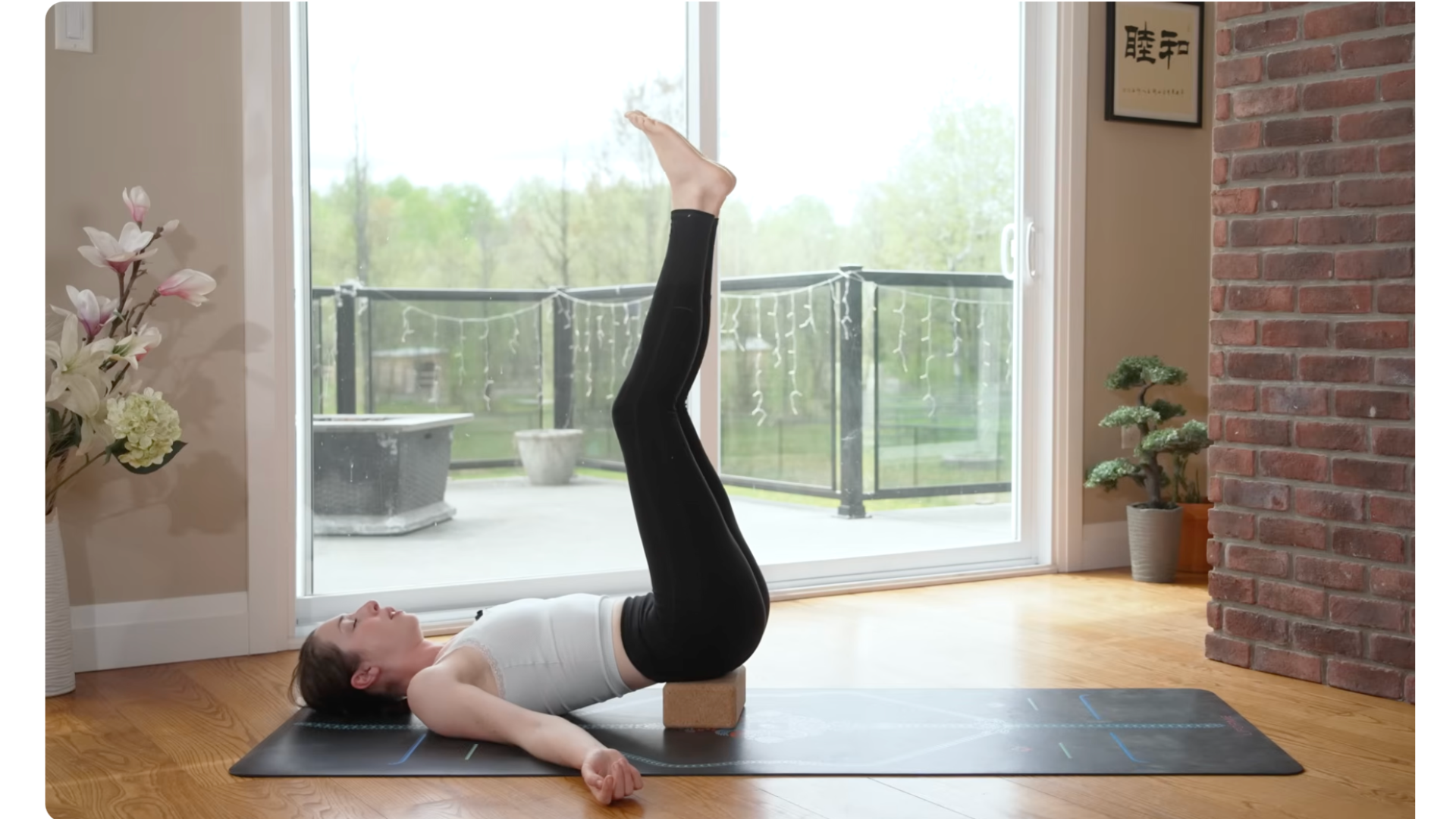 Woman with her lower hips on a block and her legs reaching toward the ceiling
