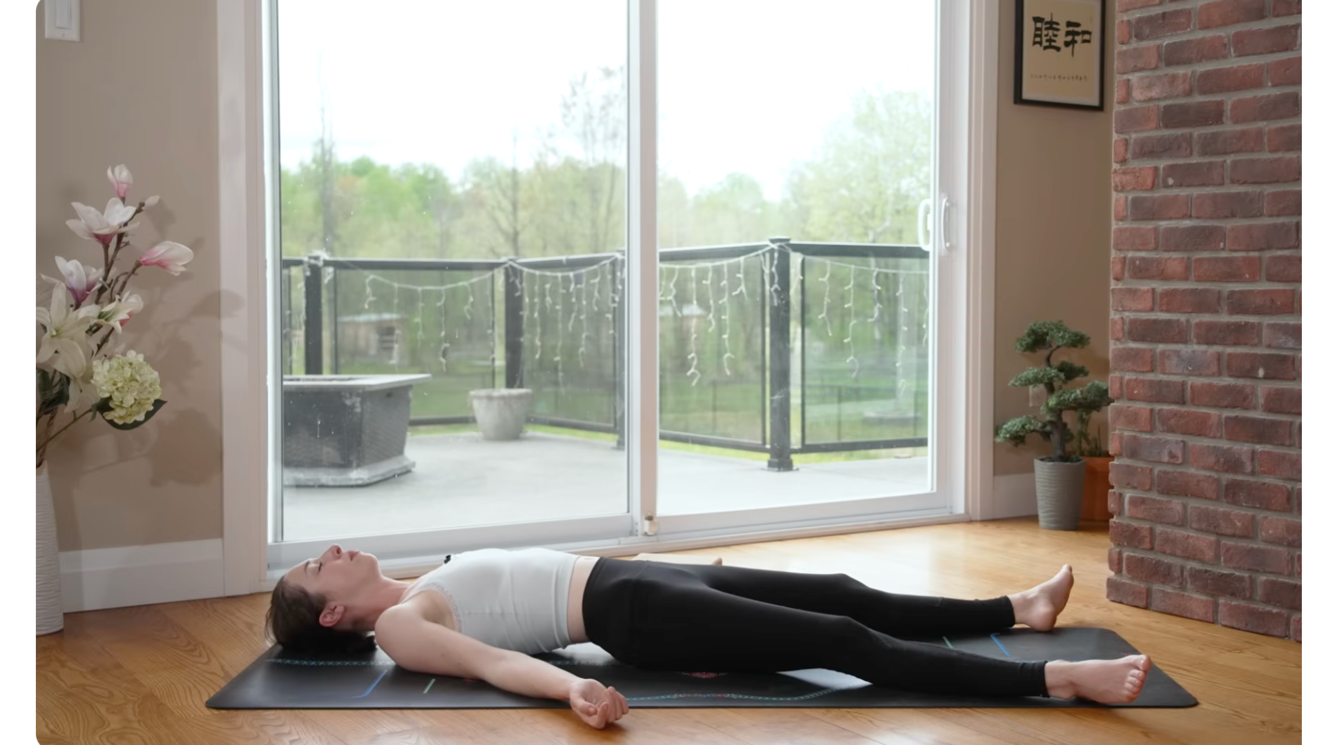 Woman lying on a yoga mat after gentle yoga for stress in Savasana