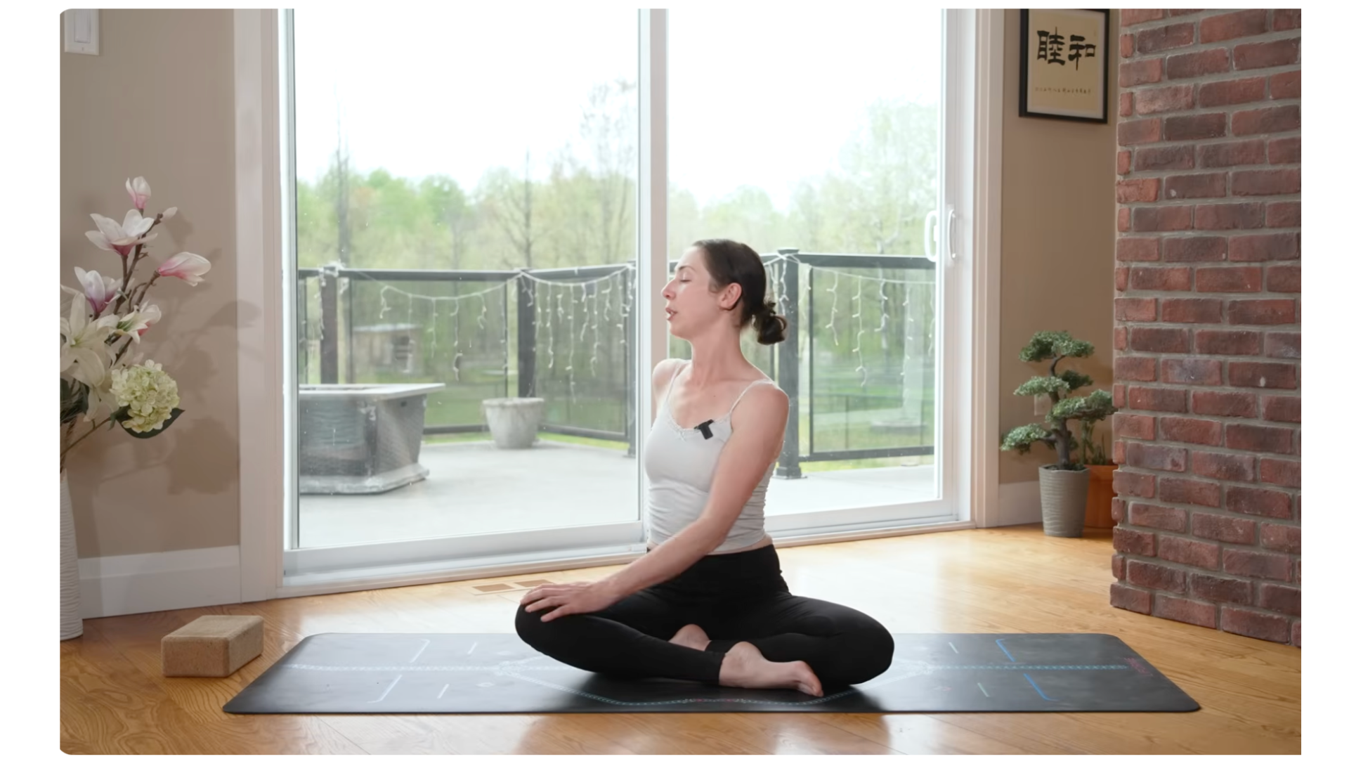 woman sitting on a yoga mat cross-legged while twisting to the side