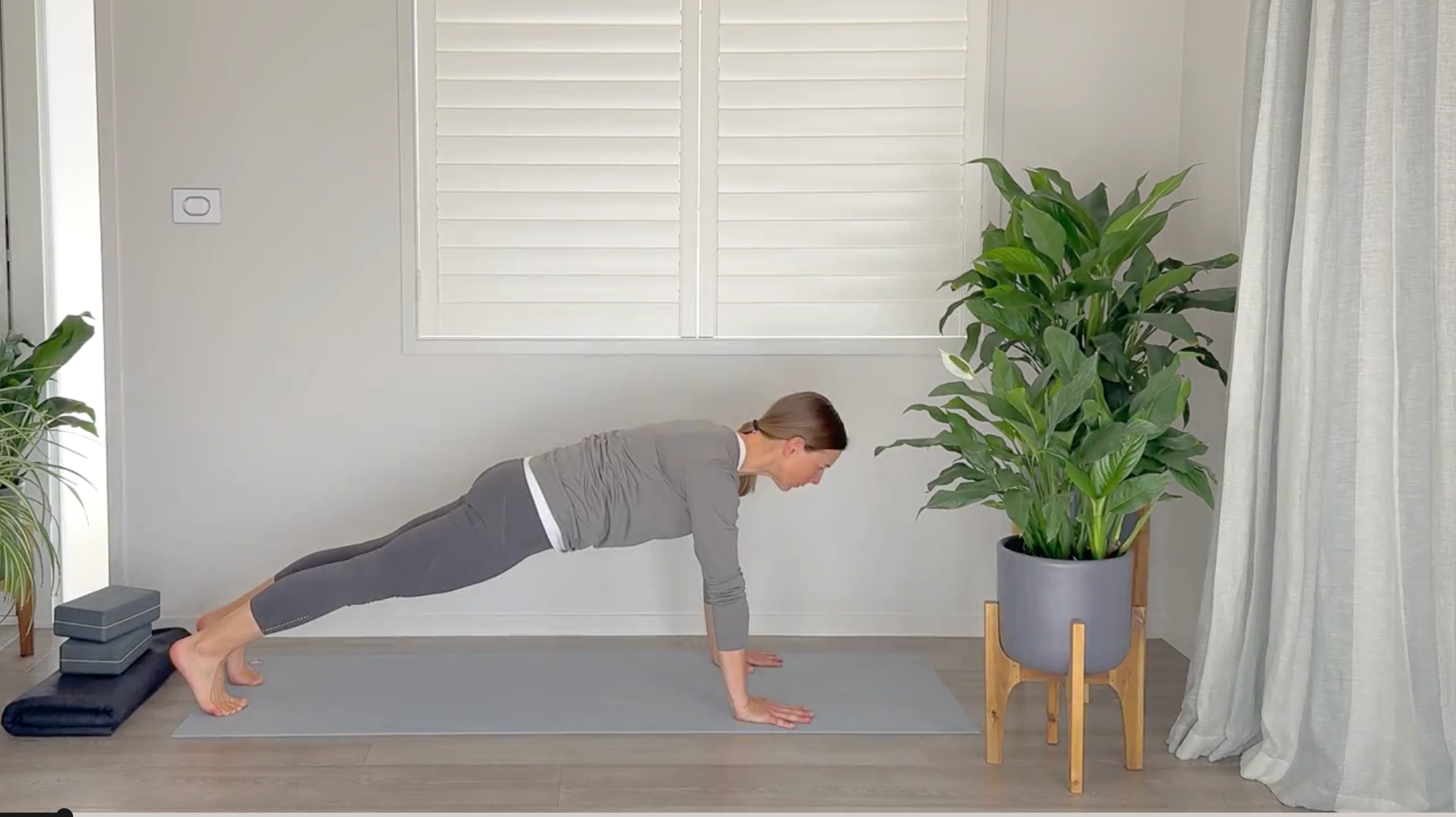 Woman on a yoga mat in Plank Pose leaning her head too far forward