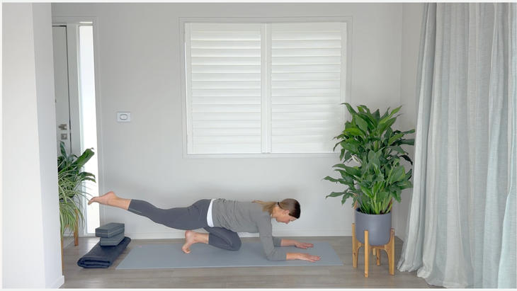 Yoga teacher on a mat with her toes tucked under to practice strong glutes