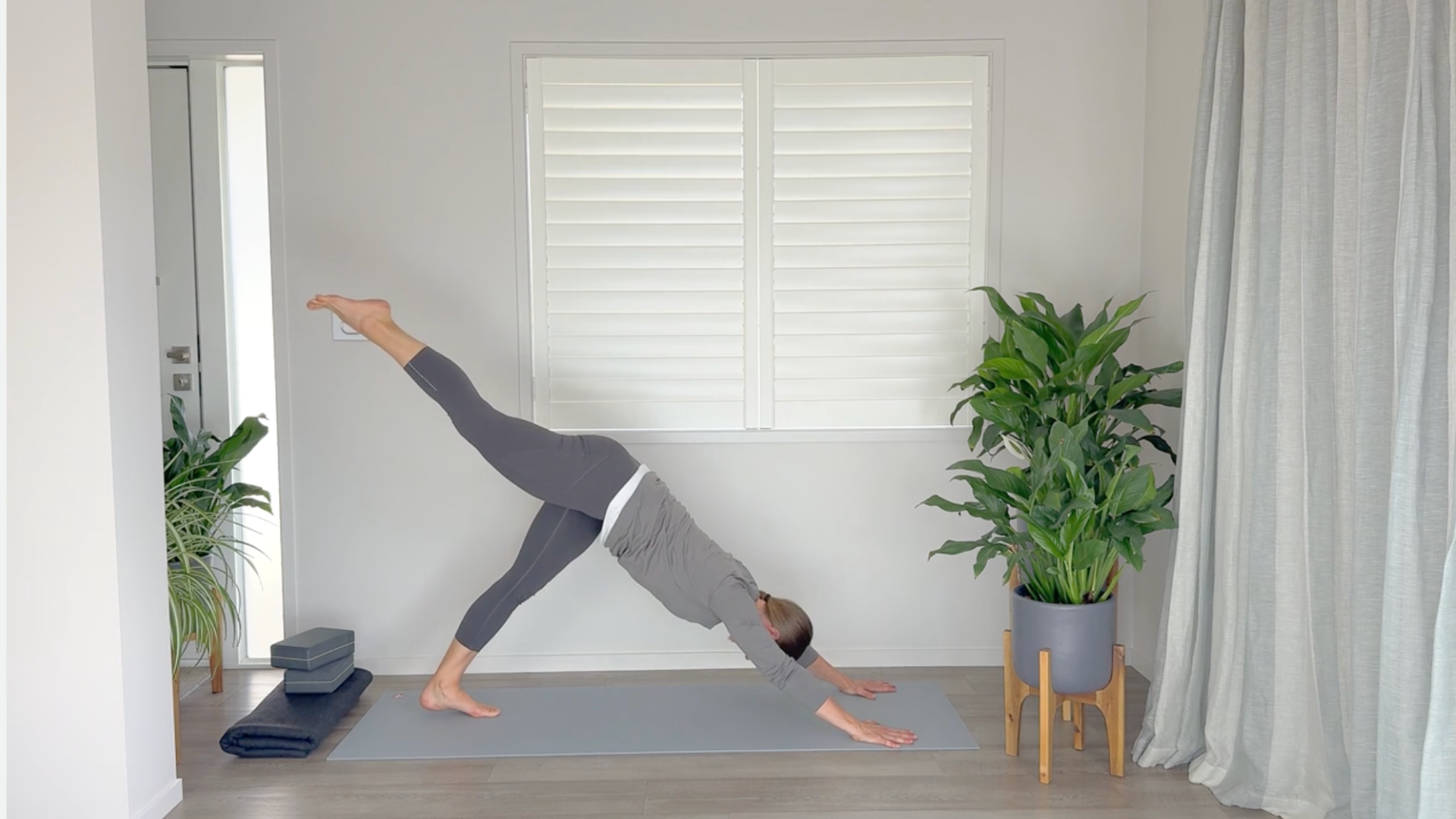 Yoga teacher moving from Downward Dog to Three-Legged Dog