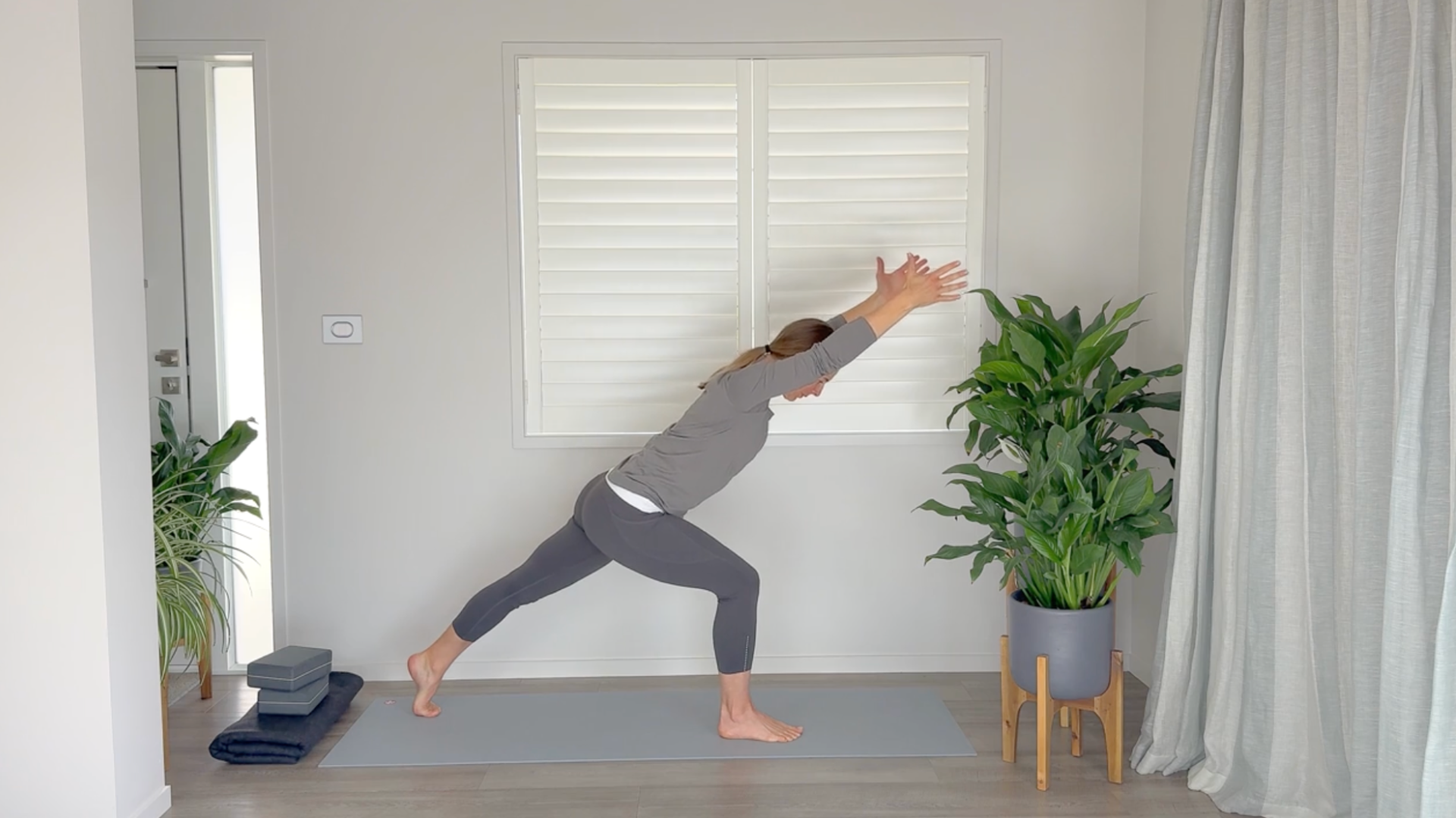 Yoga teacher on a mat practicing hip-strengthening exercises including High Lunge