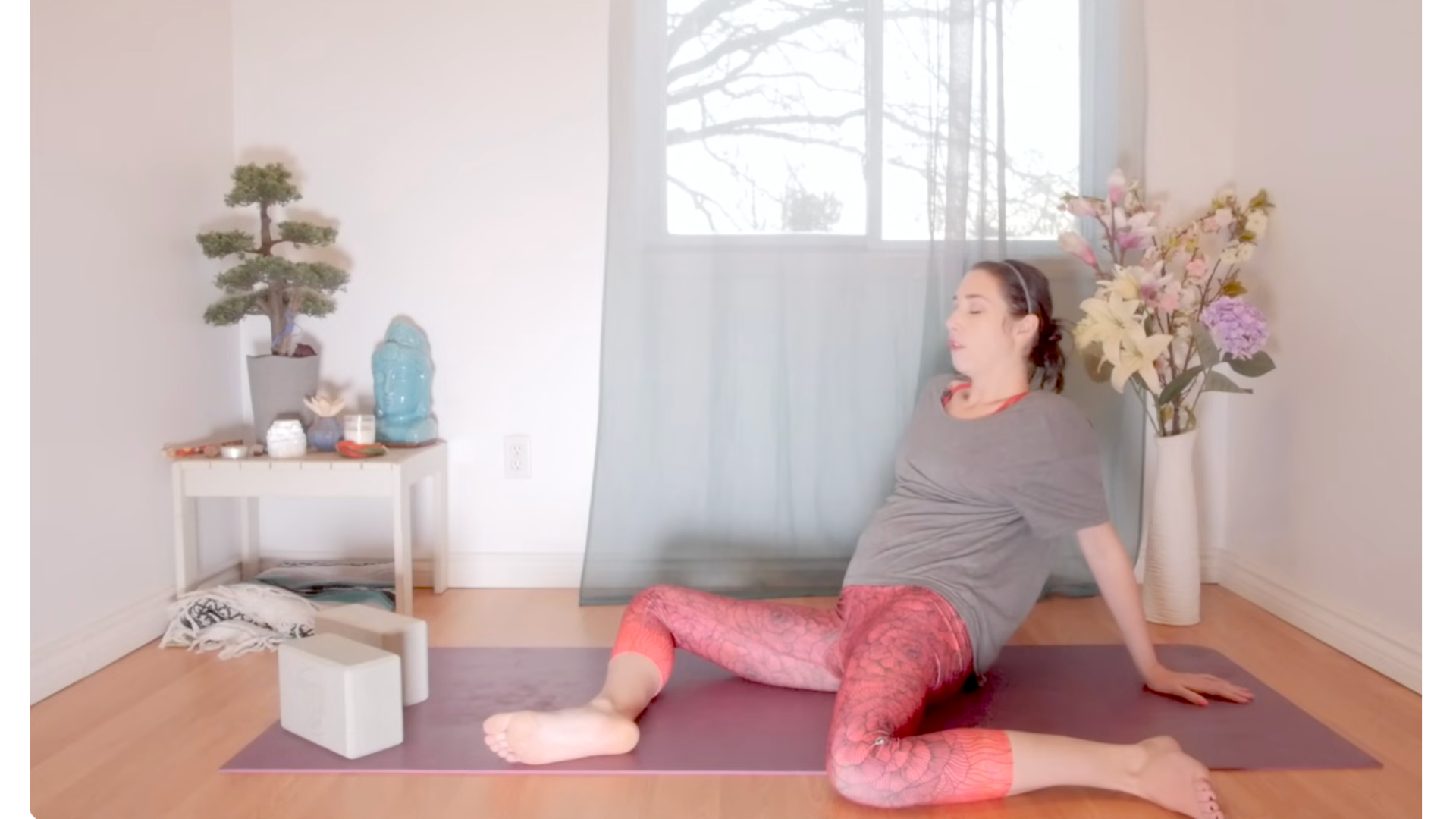 Woman lying on a mat in the yin yoga pose Deer also known as 90/90