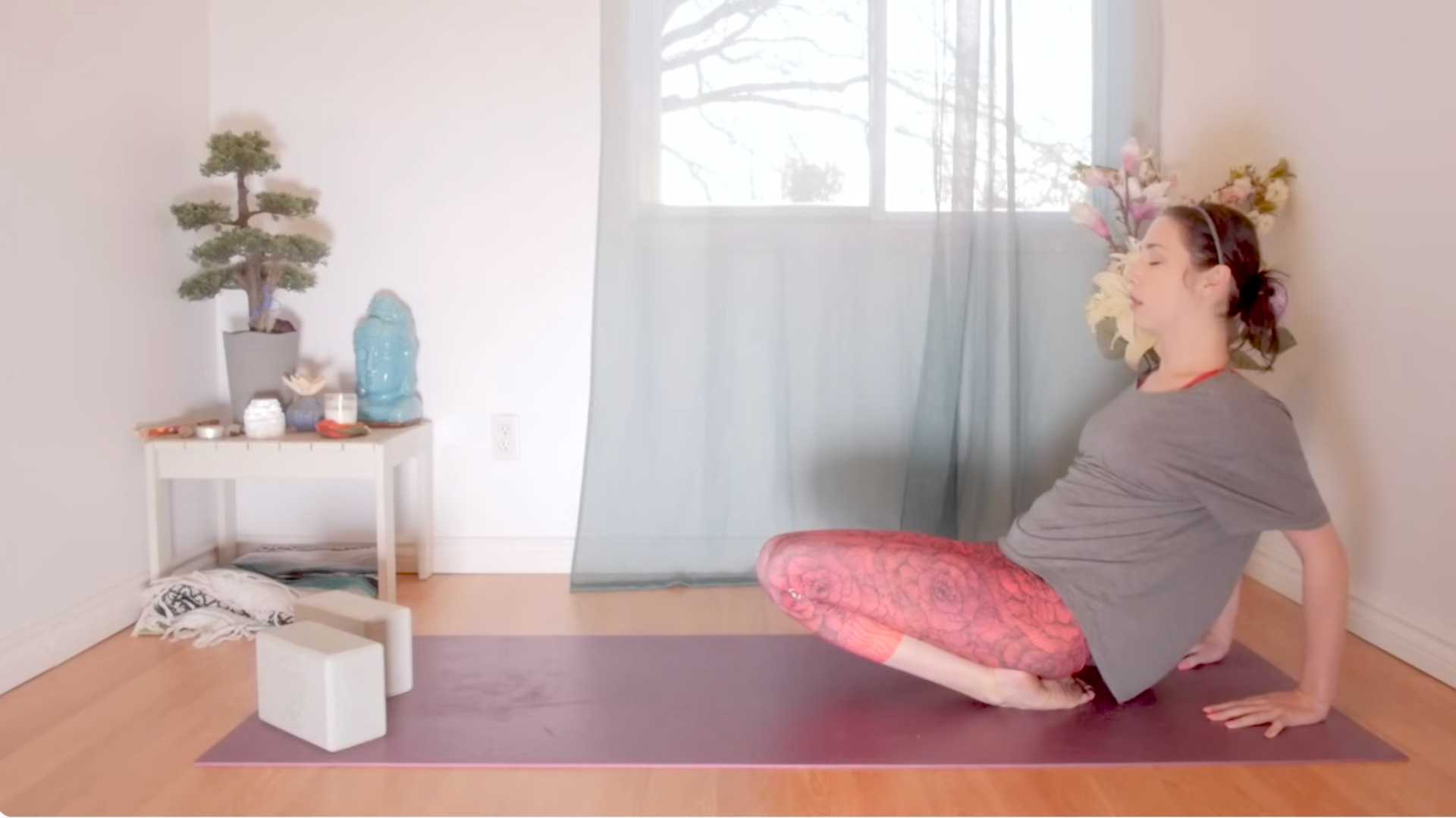Woman kneeling on a yoga mat and leaning back on the tops of her ankles to stretch