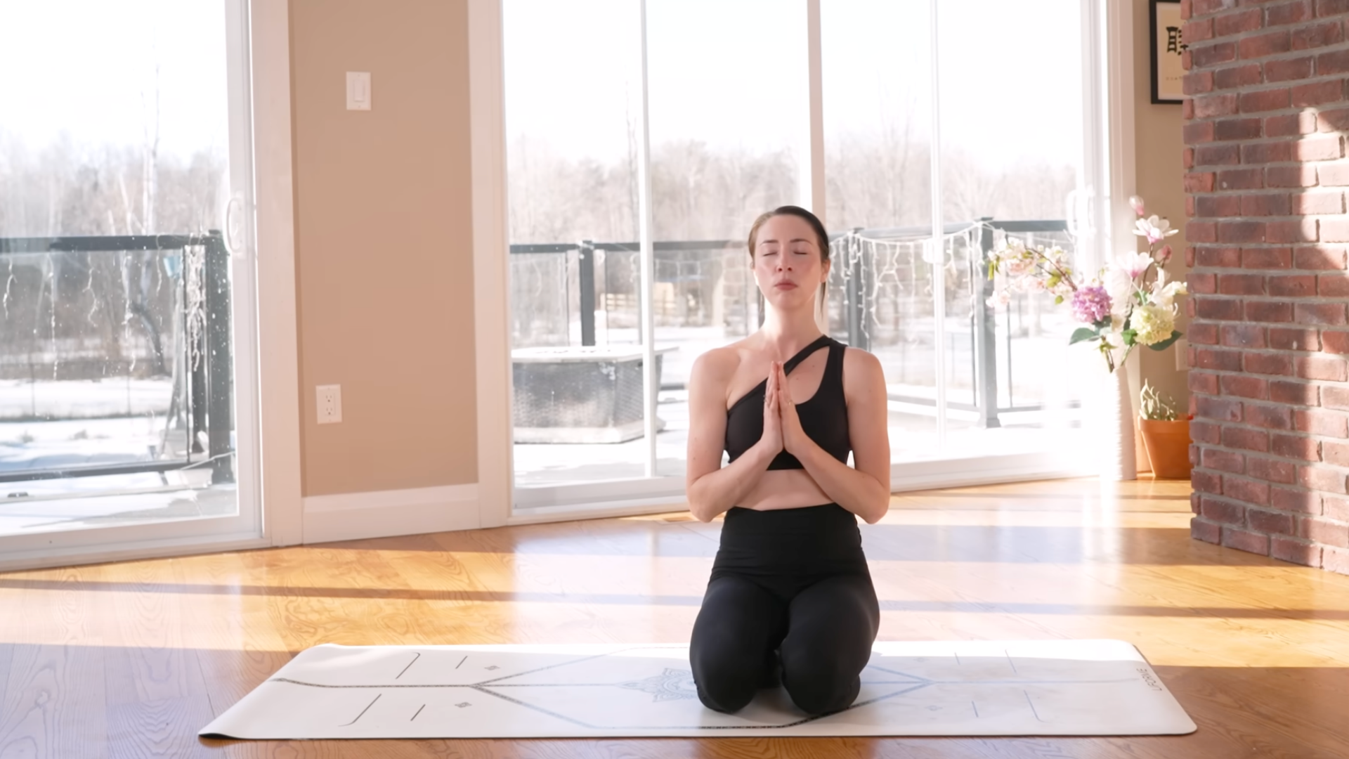 Yoga teacher kneeling on a mat during 10-minute morning yoga