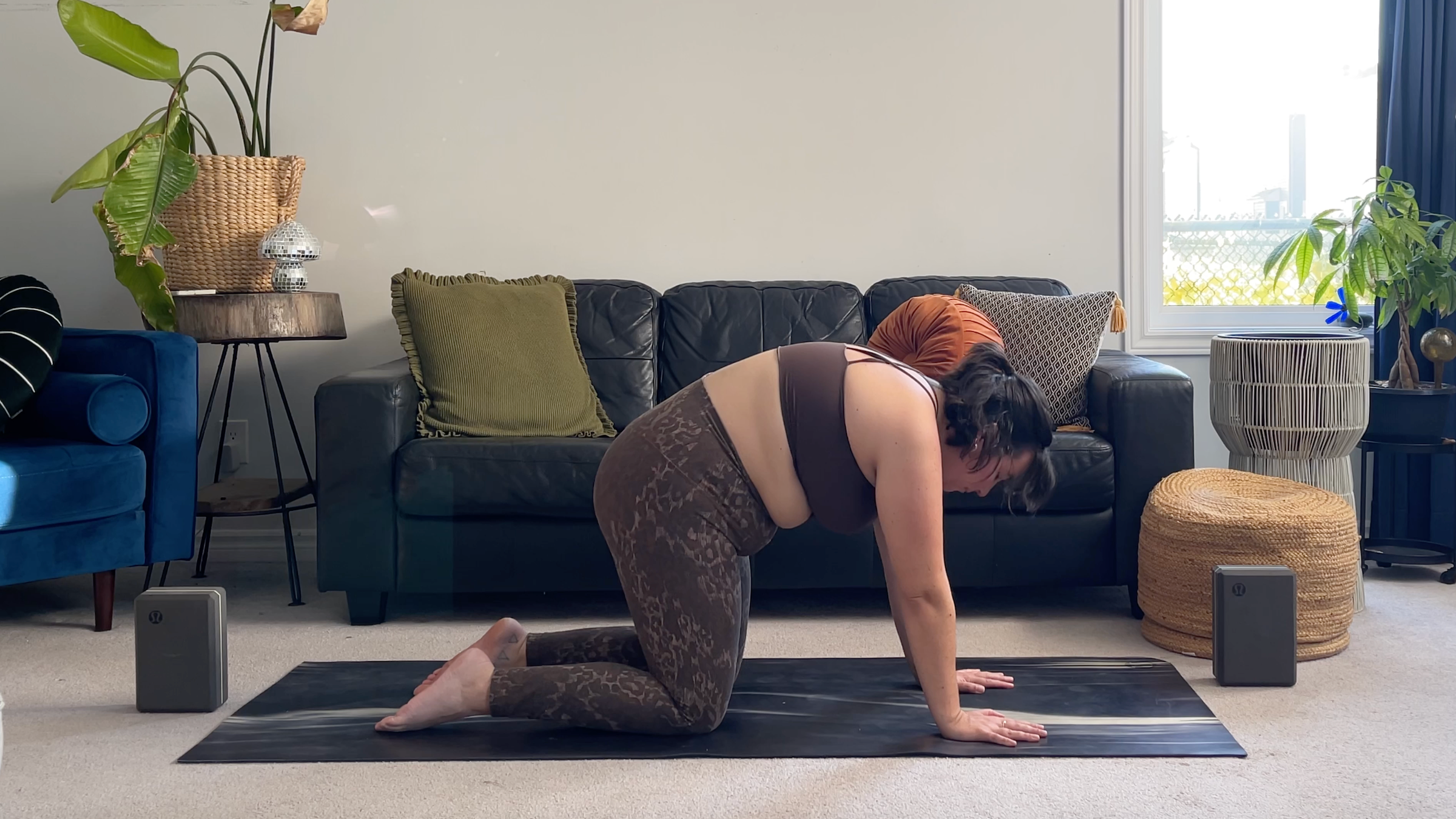 Yoga teacher Taylor Lorenz in Cat Pose, part of her full moon yoga flow