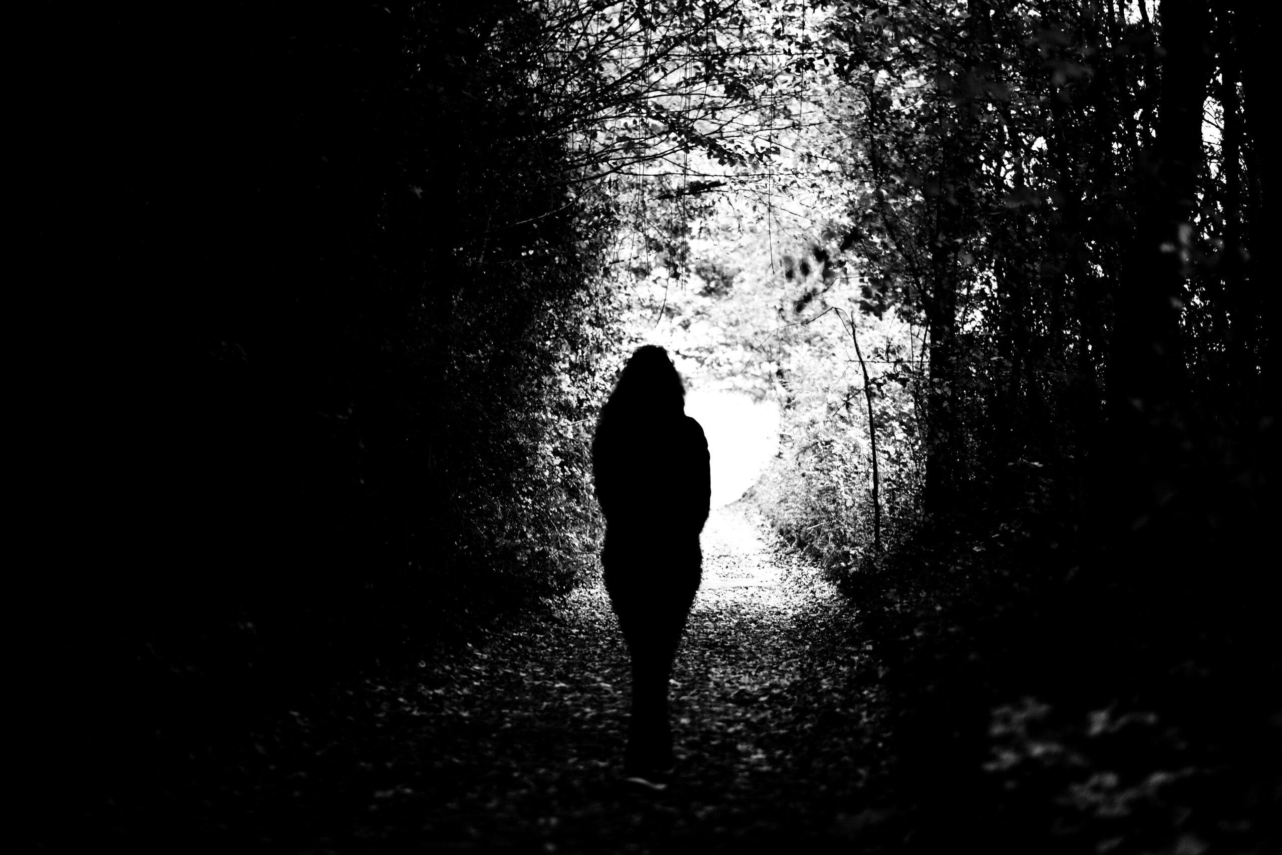Woman walking during the fall among trees contemplating her weekly horoscope for October 5-11, 2025.