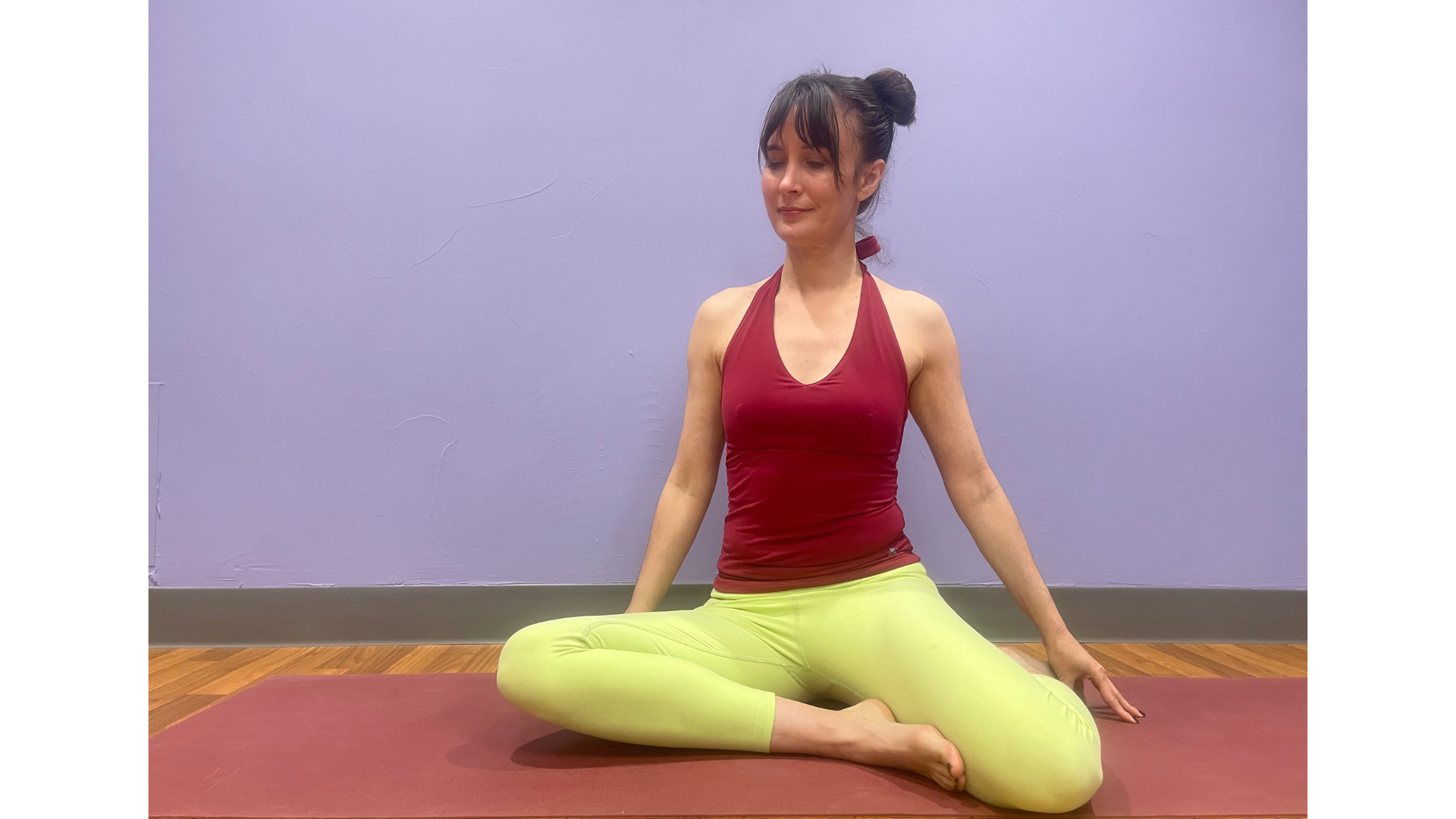 Woman sitting on a mat with her knees bent at 90 degrees while stretching