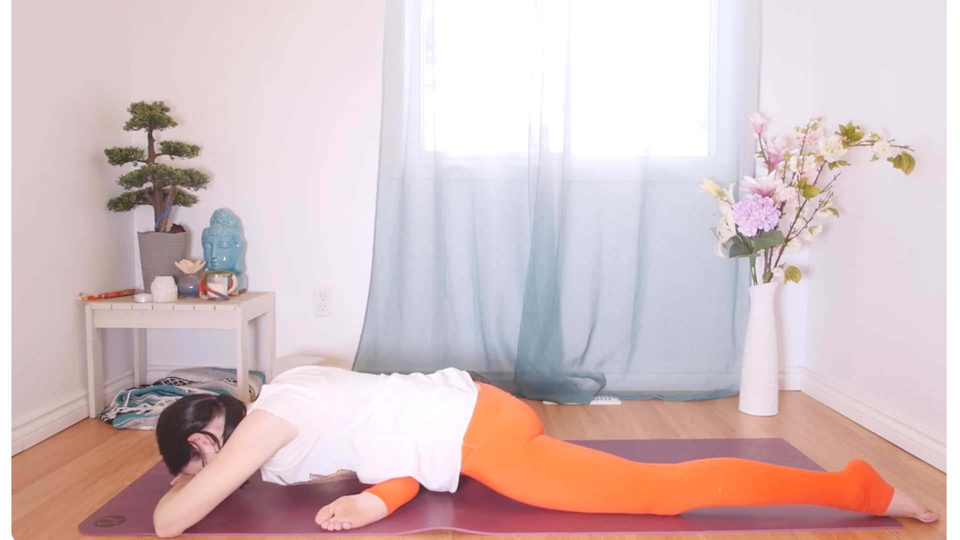 Woman lying on her belly on a yoga mat in a yin yoga pose