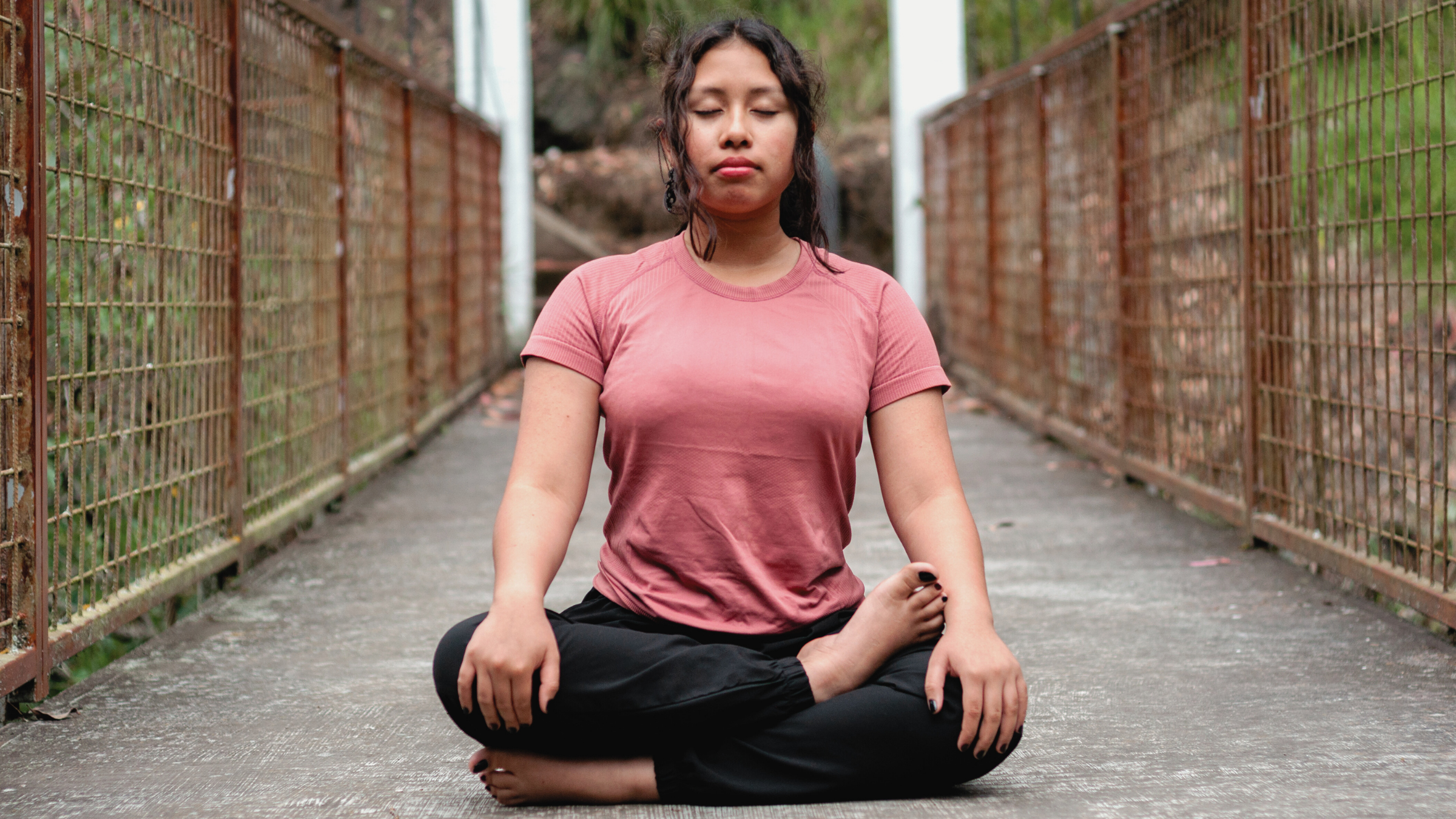 A woman sitting in Cow Face Pose, part of a yoga for anxiety flow