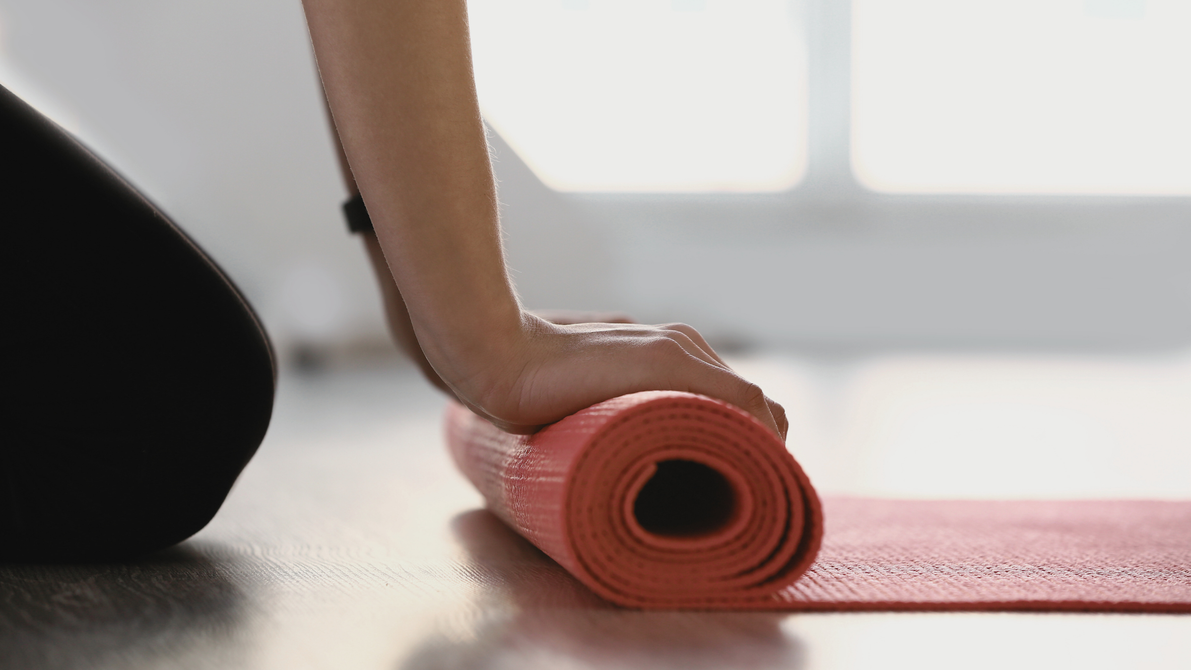 a woman rolling out her yoga mat