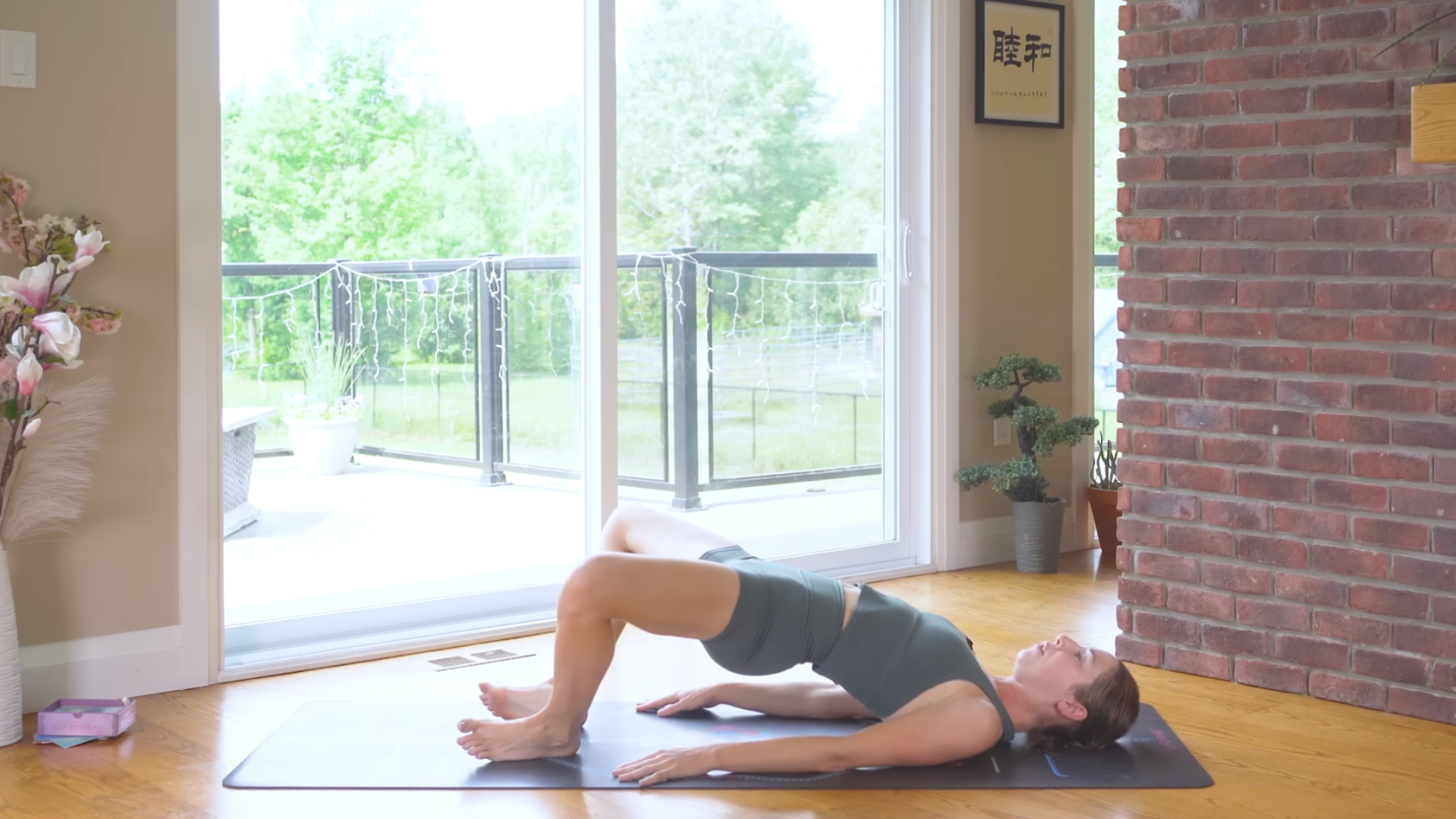 Woman practicing Shoulder Bridge on a yoga mat