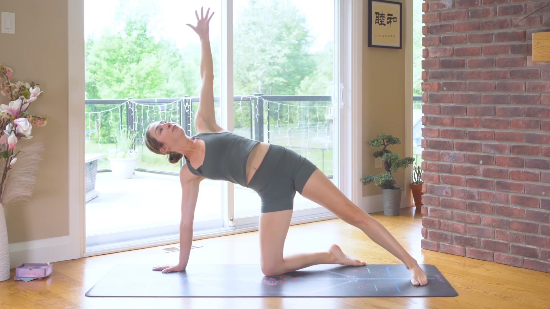 Woman kneeling on a yoga mat during 10-minute morning yoga and pilates in a version of Side Plank