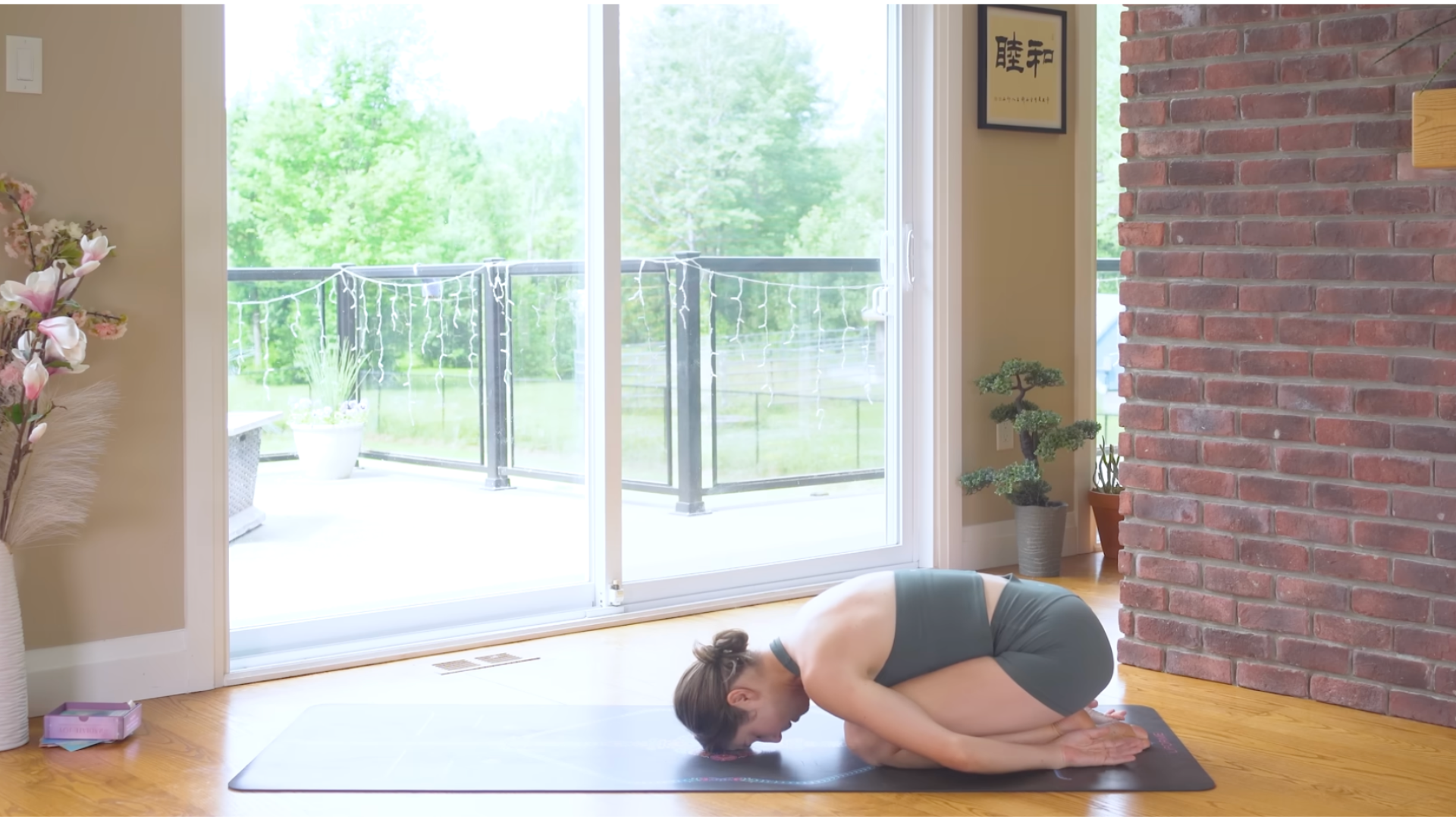 Woman kneeling with her forehead on the yoga mat in Child's Pose