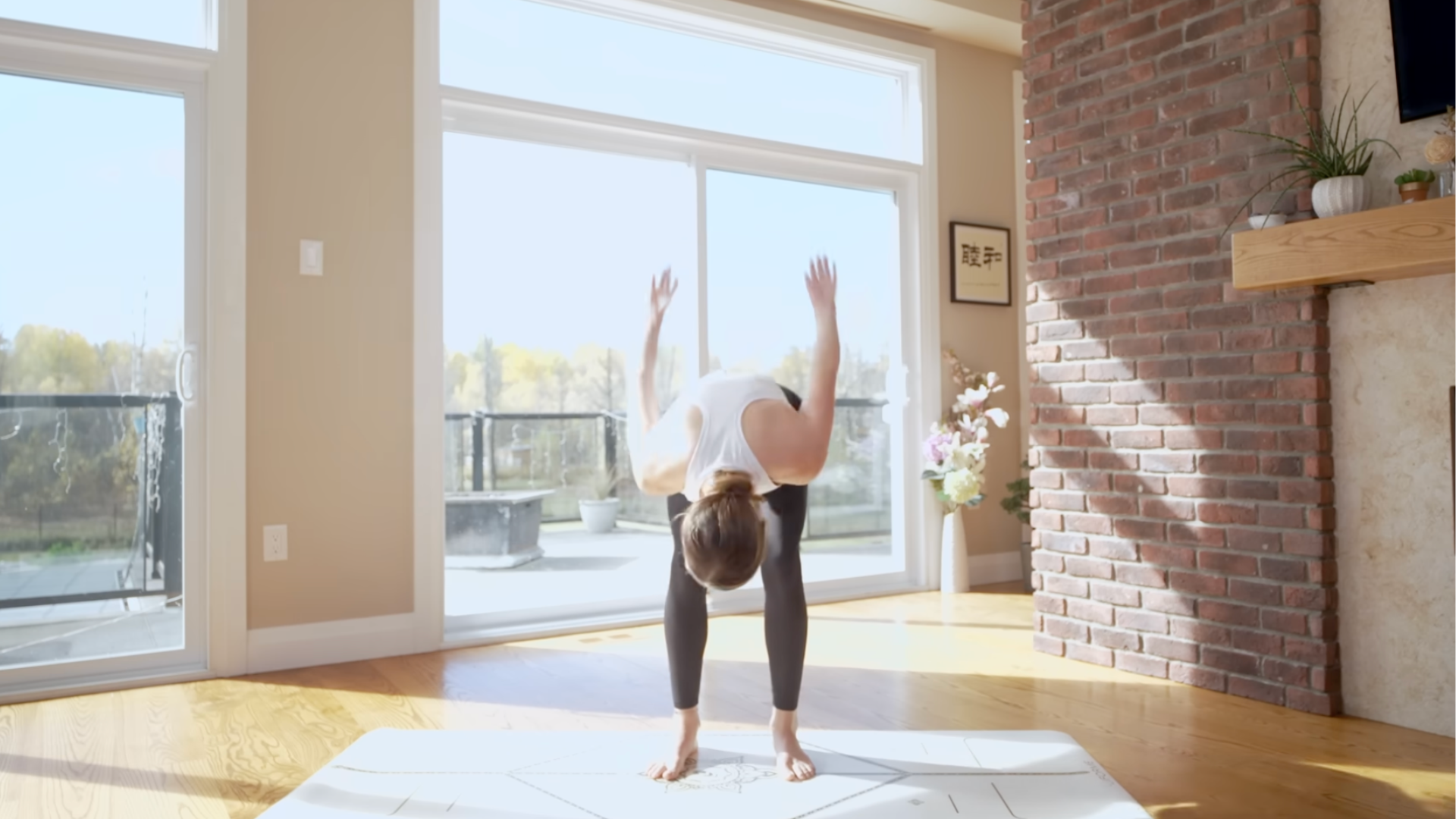 Yoga teacher on a mat leaning forward in Breath of Joy