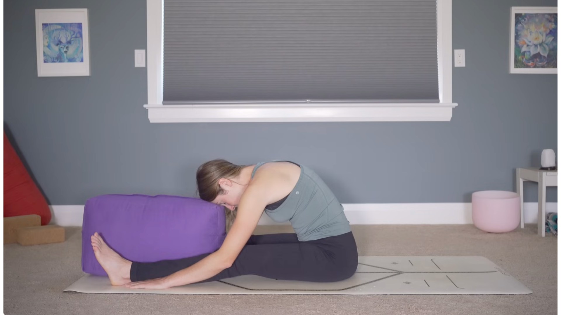 Woman sitting on the floor leaning forward during bedtime yoga