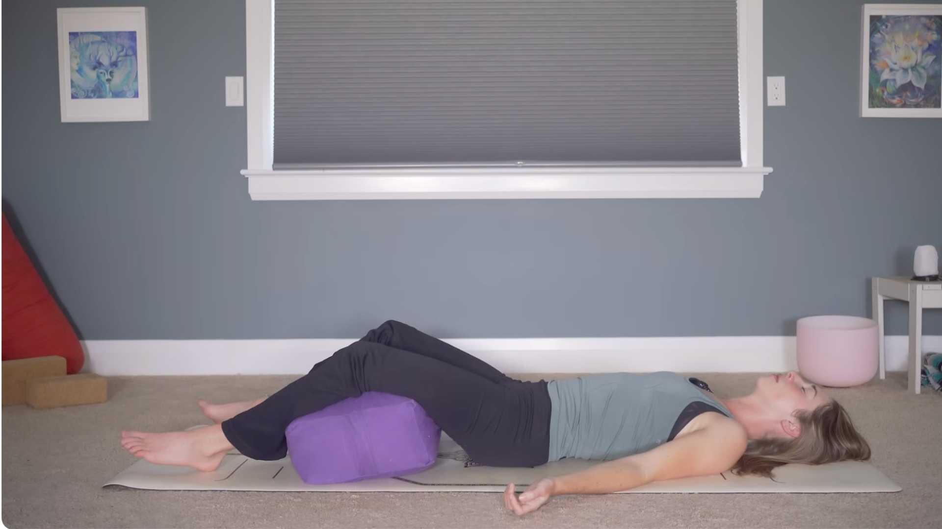 Woman lying on her back with a bolster beneath her knees