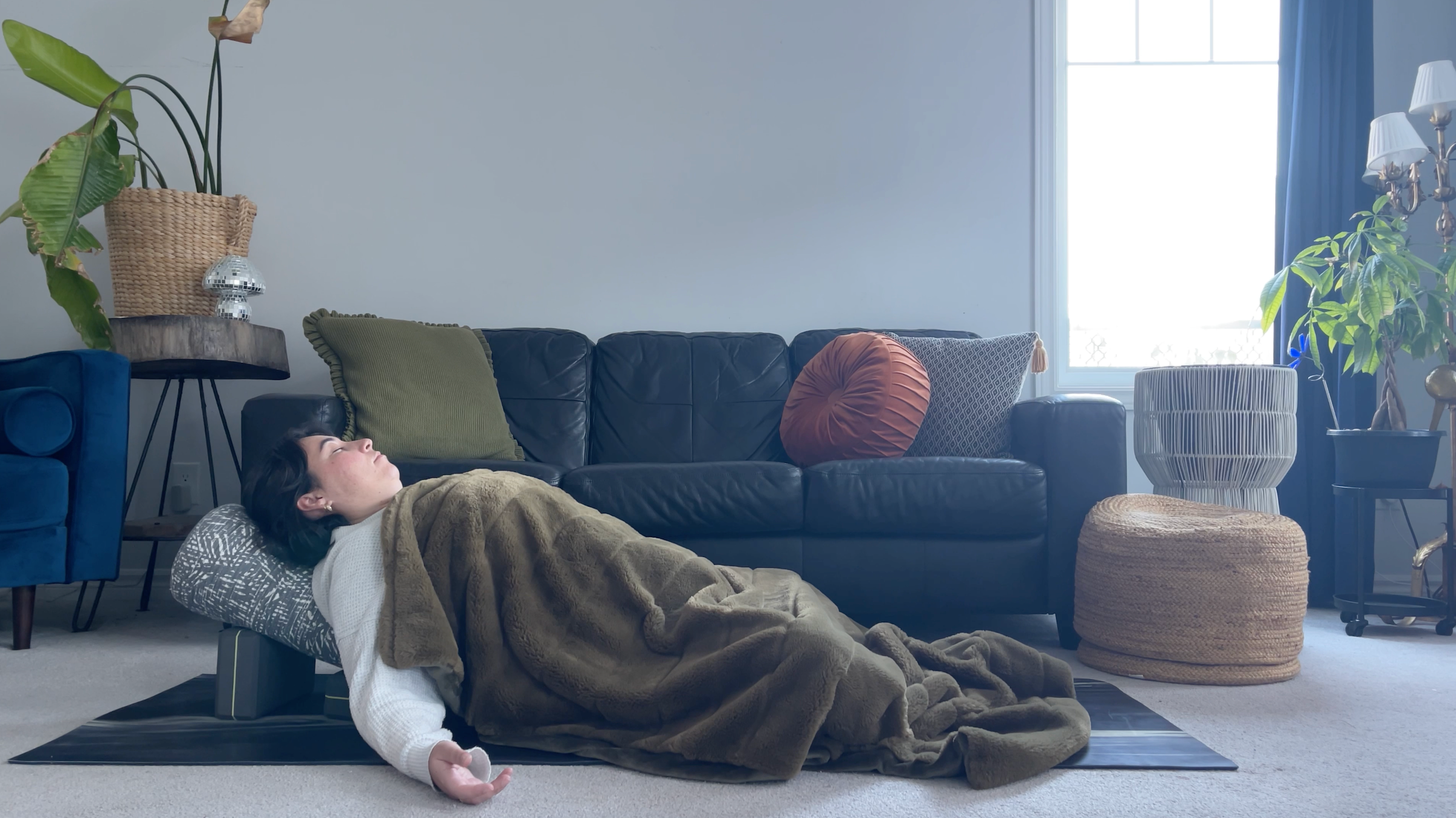 Yoga teacher Taylor Lorenz in Supported Savasana