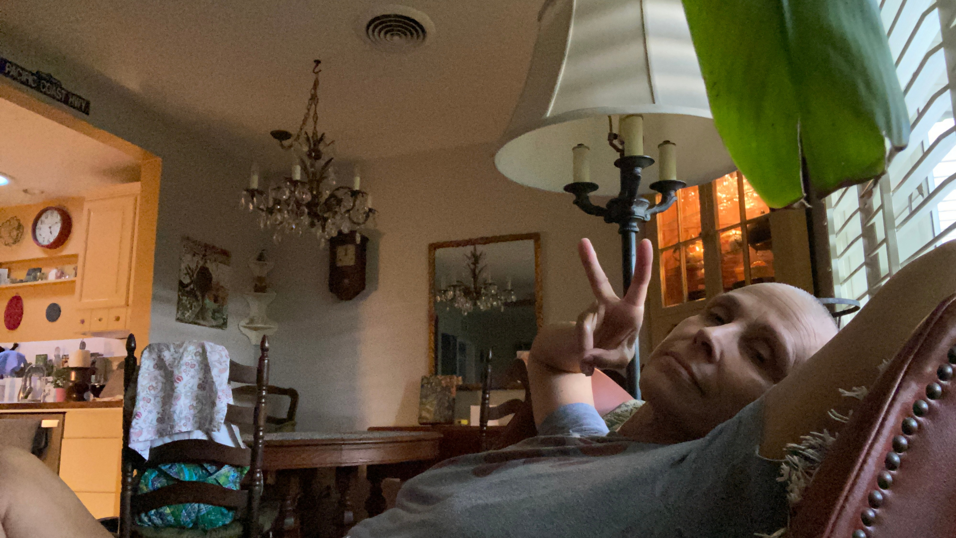 Yoga teacher Nancy Ferraro sitting on her couch with a shaved head during her cancer treatment