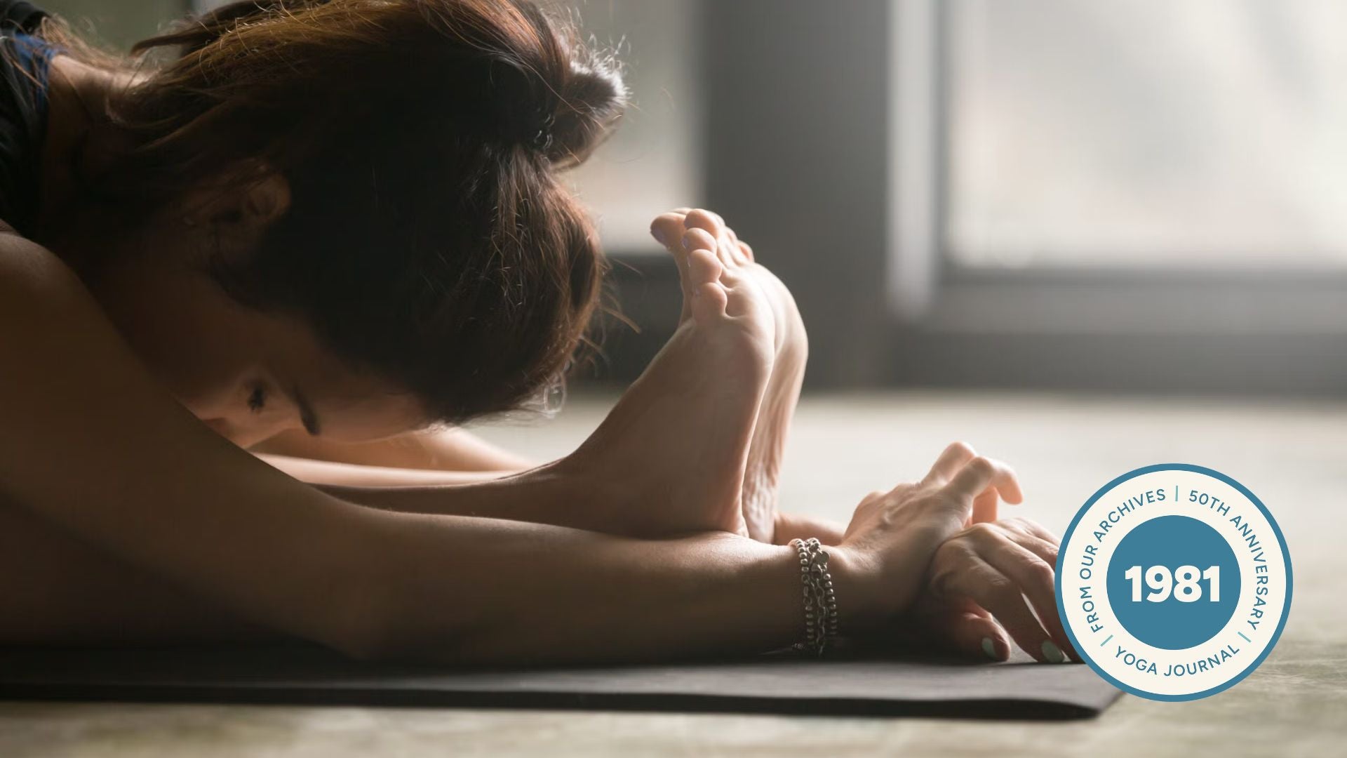 Close-up of woman stretching in standing forward bend.