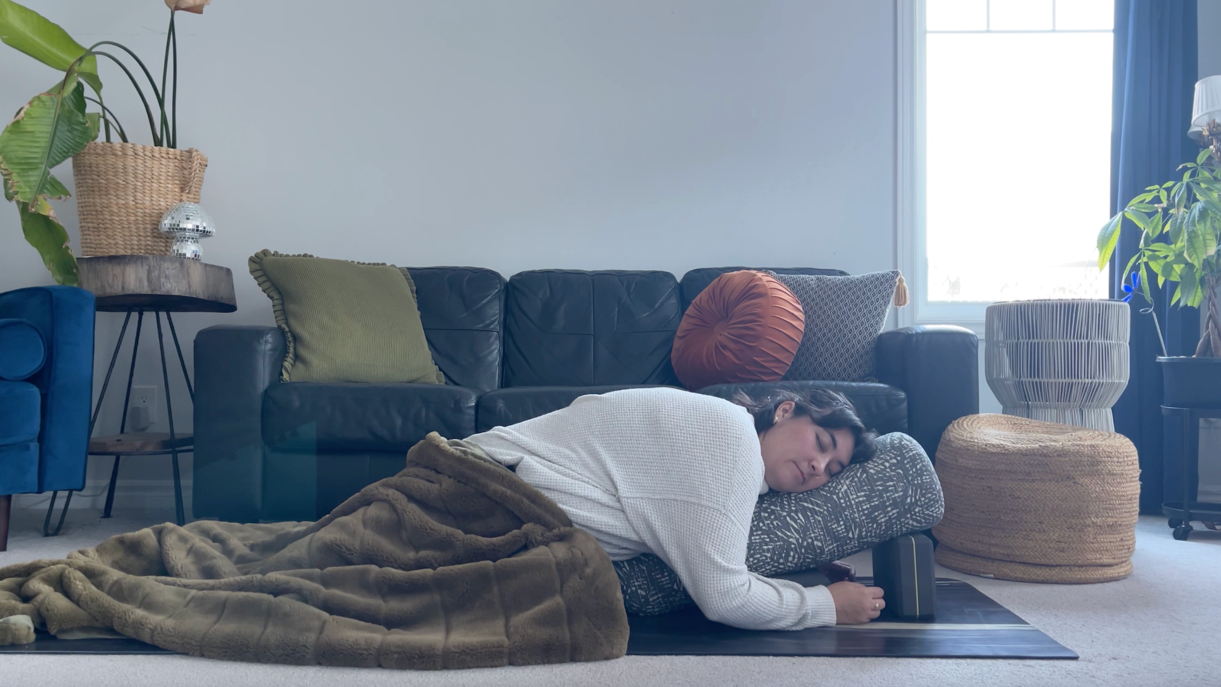 Yoga teacher Taylor Lorenz in a restorative yoga pose