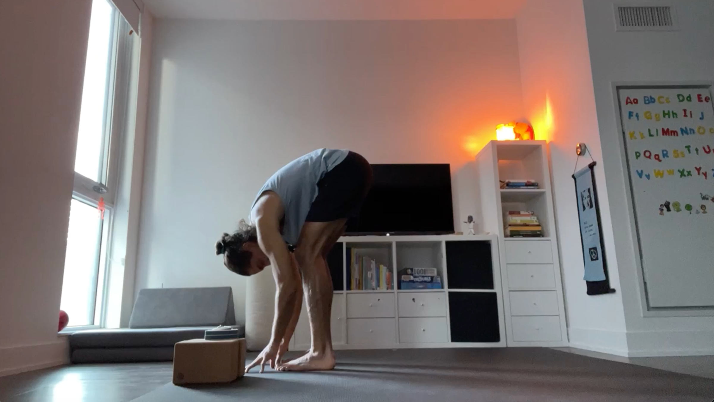 Yoga teacher Jaffer Hussain in Standing Forward Bend, part of his simple yoga flow