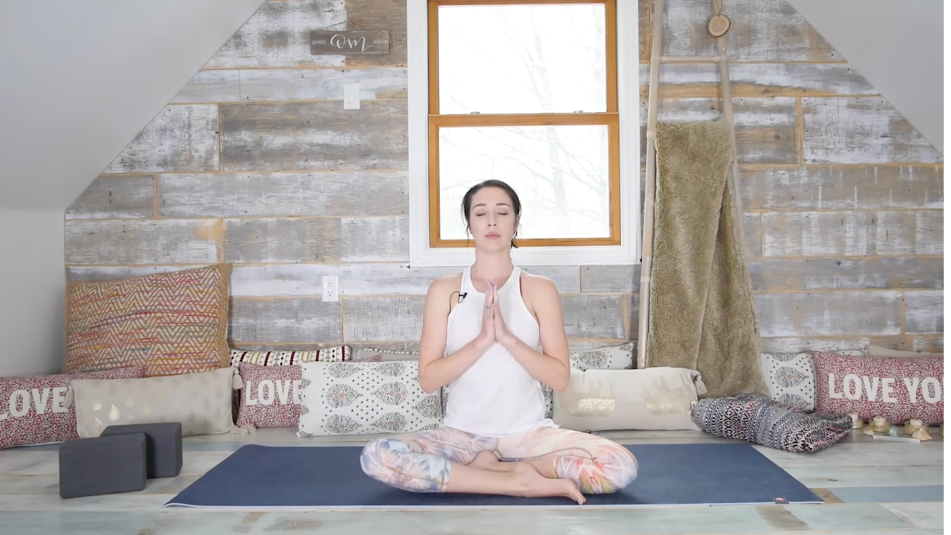 Woman sitting on a yoga mat cross-legged