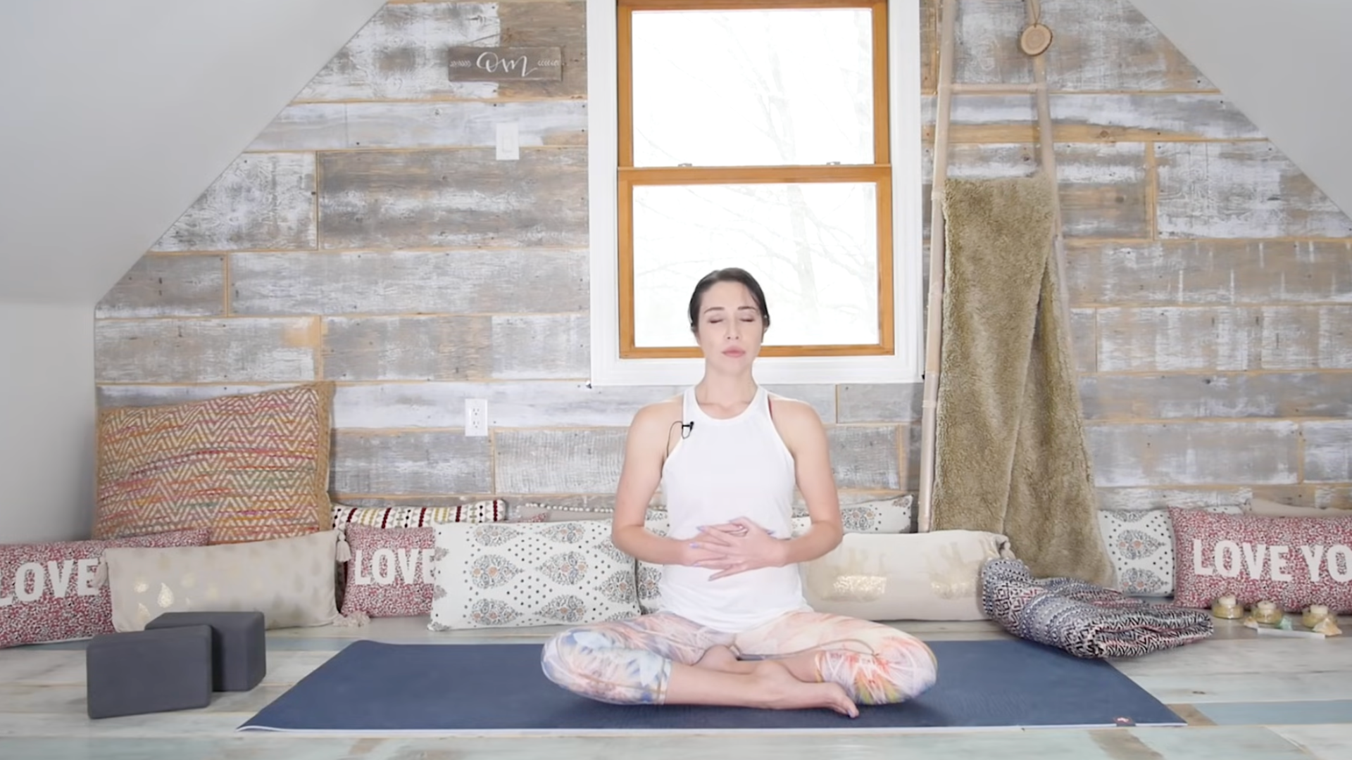 Woman sitting on a yoga mat doing yin yoga poses for the solar plexus chakra