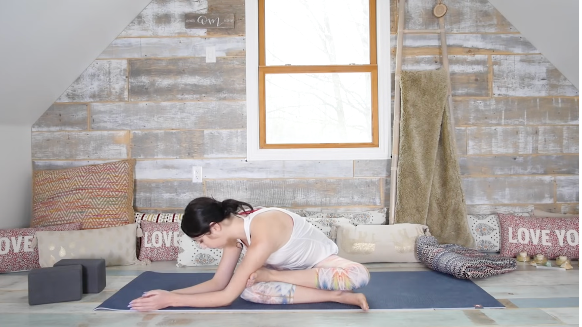 Yoga teacher sitting with her legs crossed in a yin yoga stretch