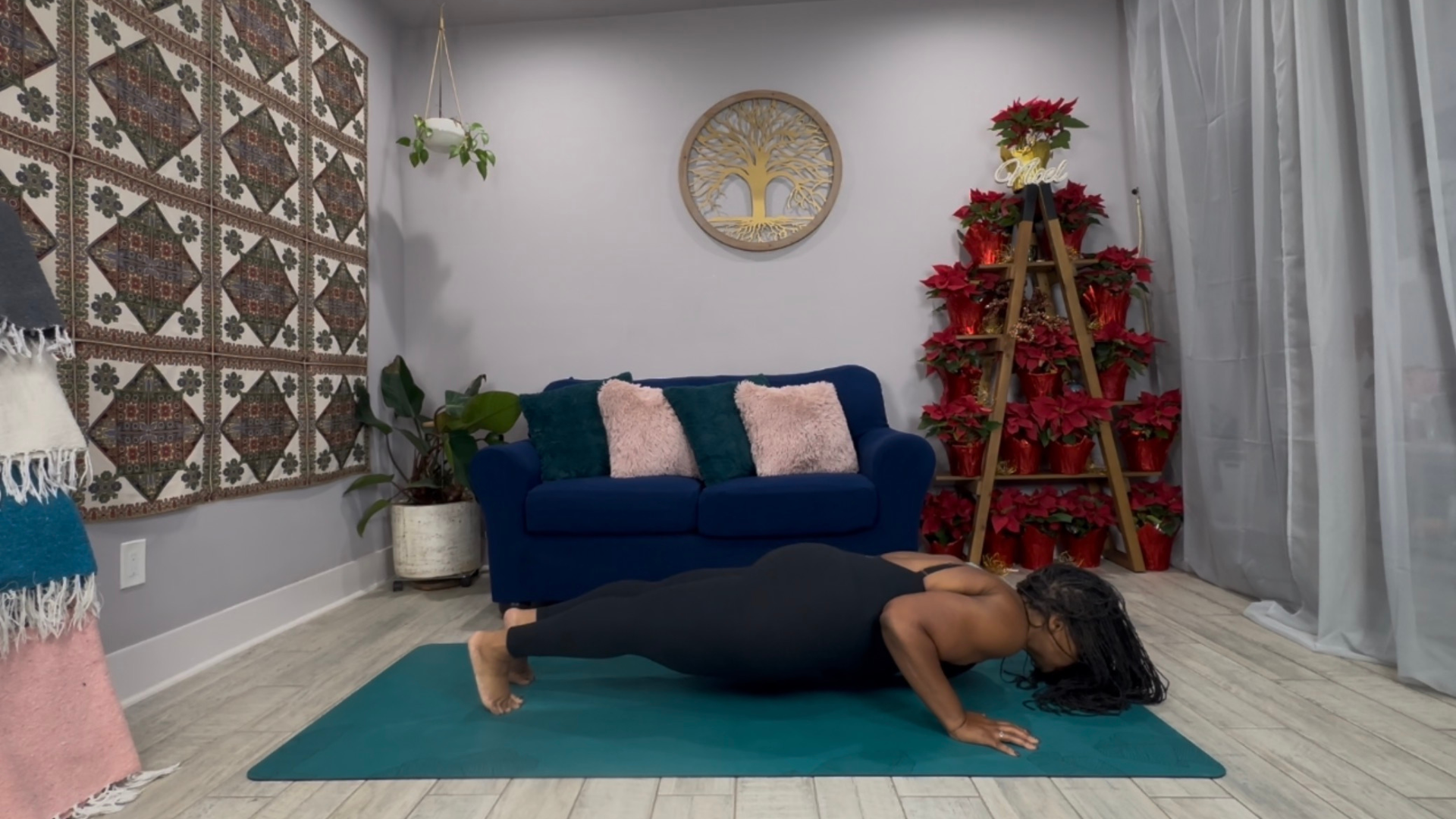 Woman on a yoga mat in the pose known as Chaturanga with her elbows bent and chest close to the mat