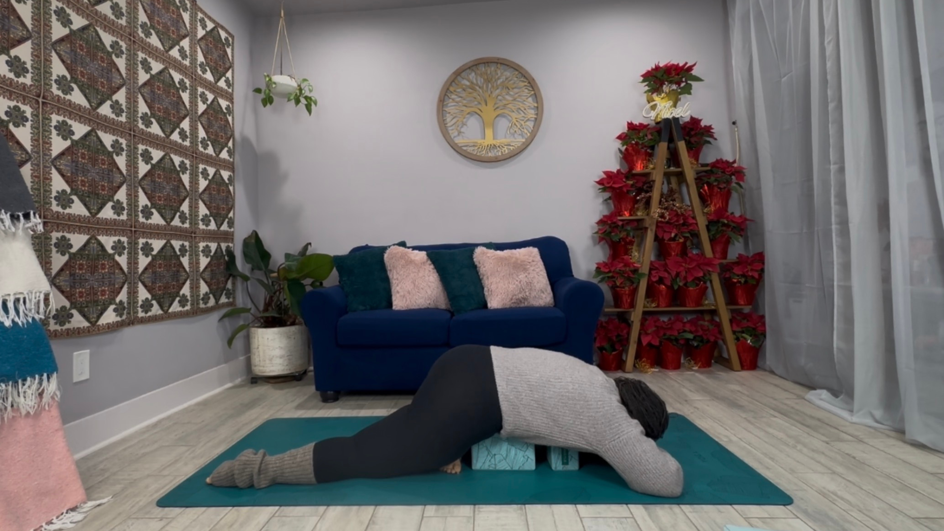 Woman practicing Sleeping Swan, a yin yoga pose, on a mat with a block beneath her hips