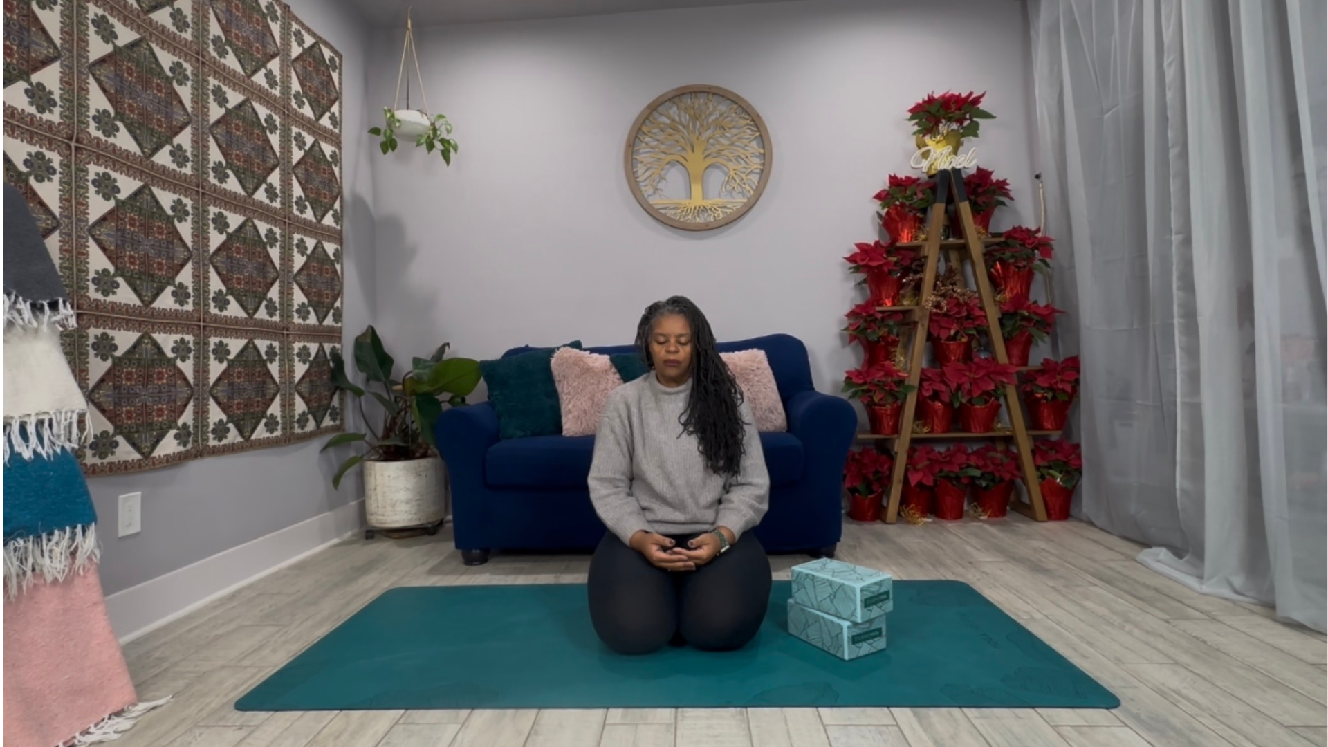 Woman kneeling on a yoga mat and sitting back on her heels