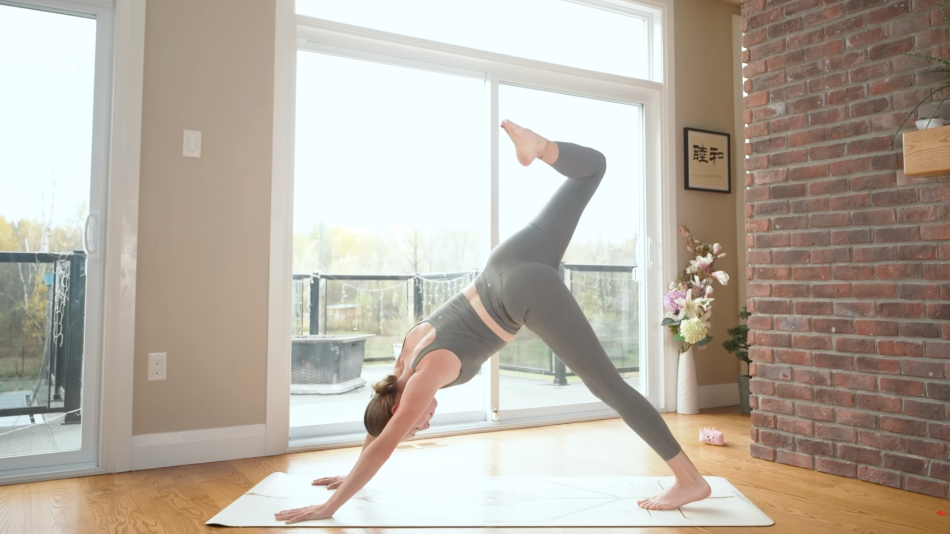 Woman on her mat in Downward-Facing Dog lifting one leg toward the ceiling