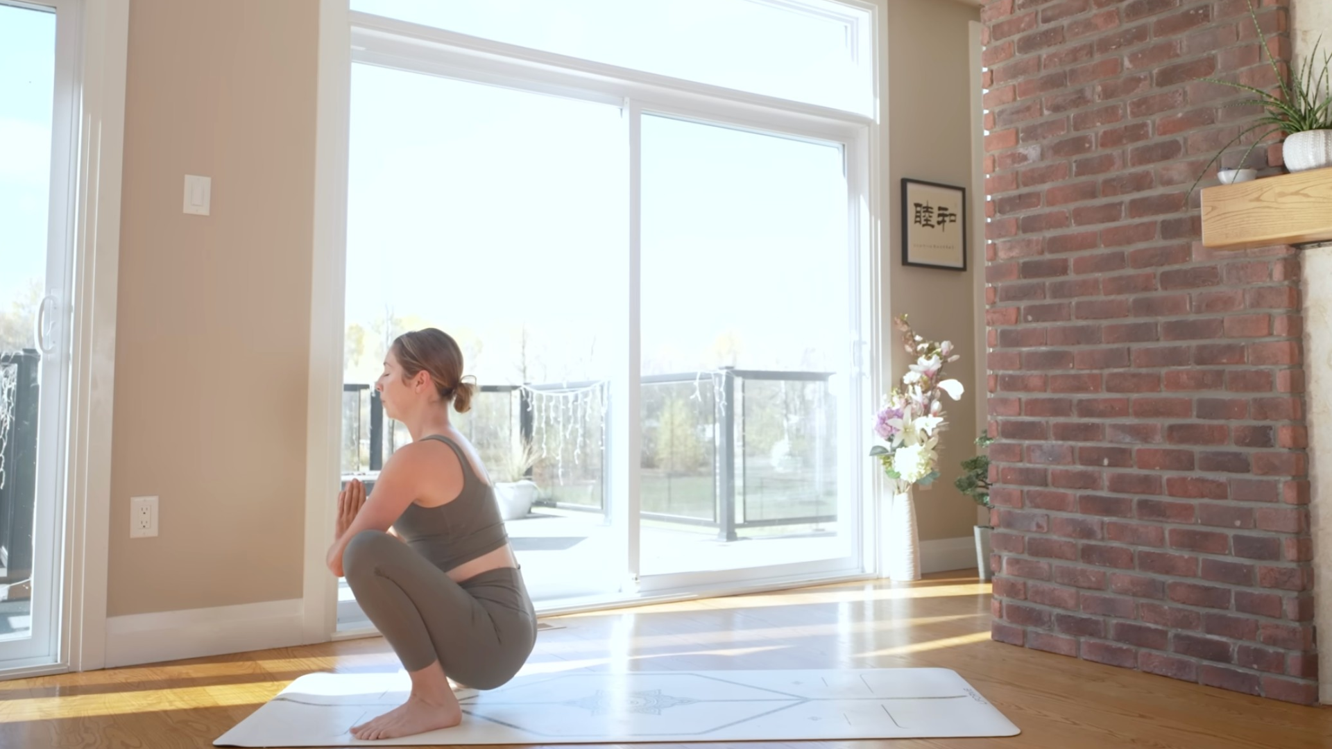Woman in a squatting position at the front of her yoga mat 
