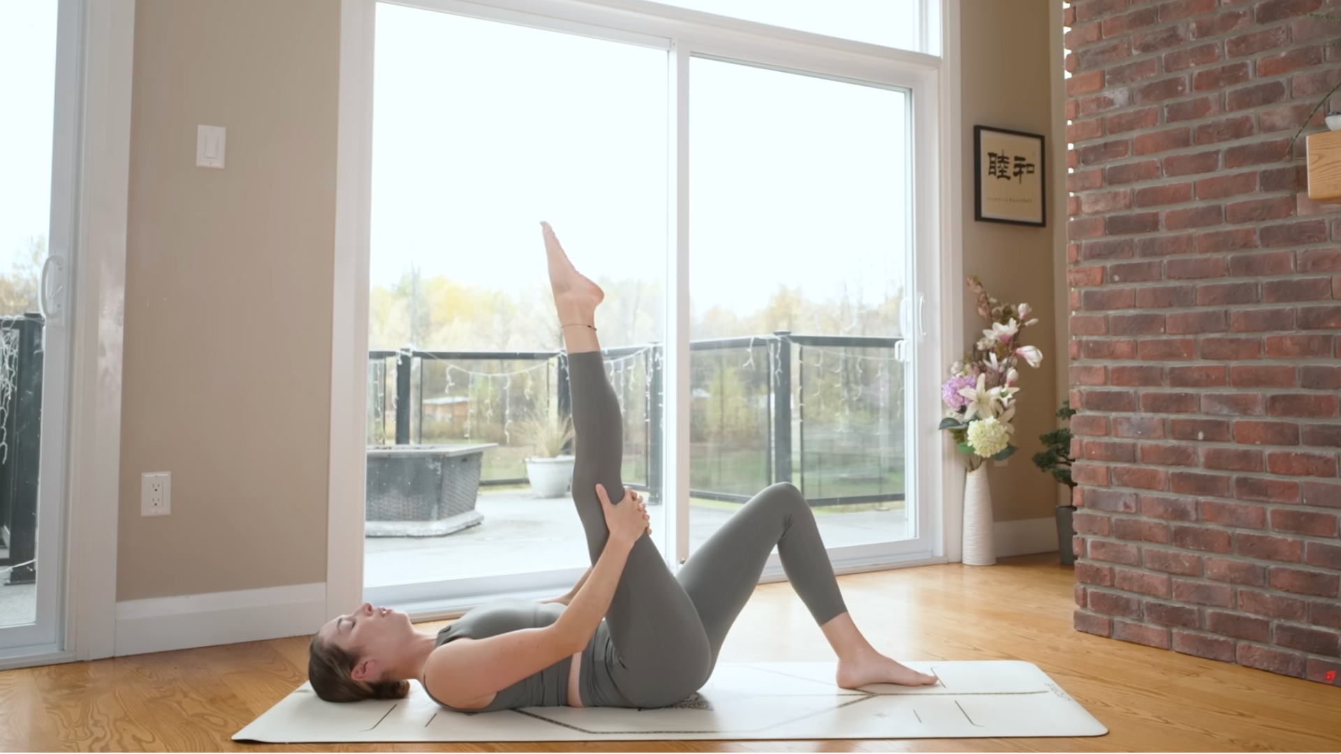 Woman lying on her back with her right leg reaching toward the ceiling in a hamstring stretch