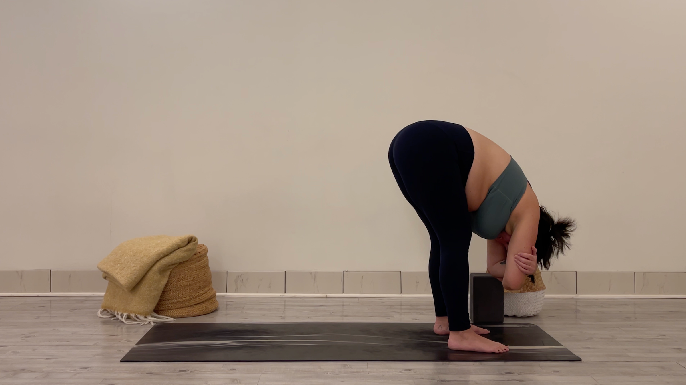 Yoga teacher Taylor Lorenz in Standing Forward Bend, part of her morning yoga practice