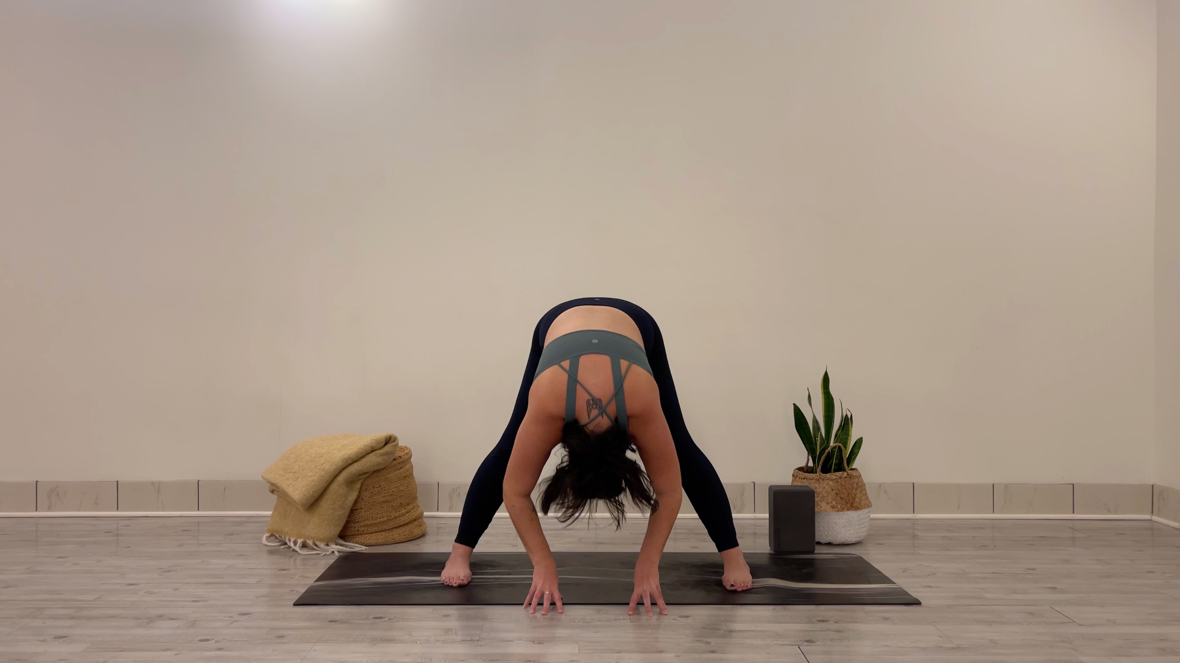 Yoga teacher Taylor Lorenz in Wide-Legged Standing Forward Bend, part of her morning yoga practice