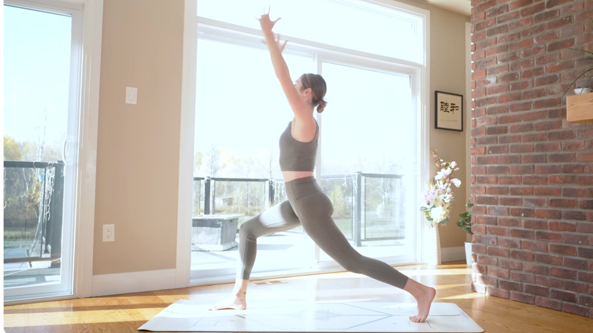 Teacher on a mat practicing high lunge during a power yoga for energy practice