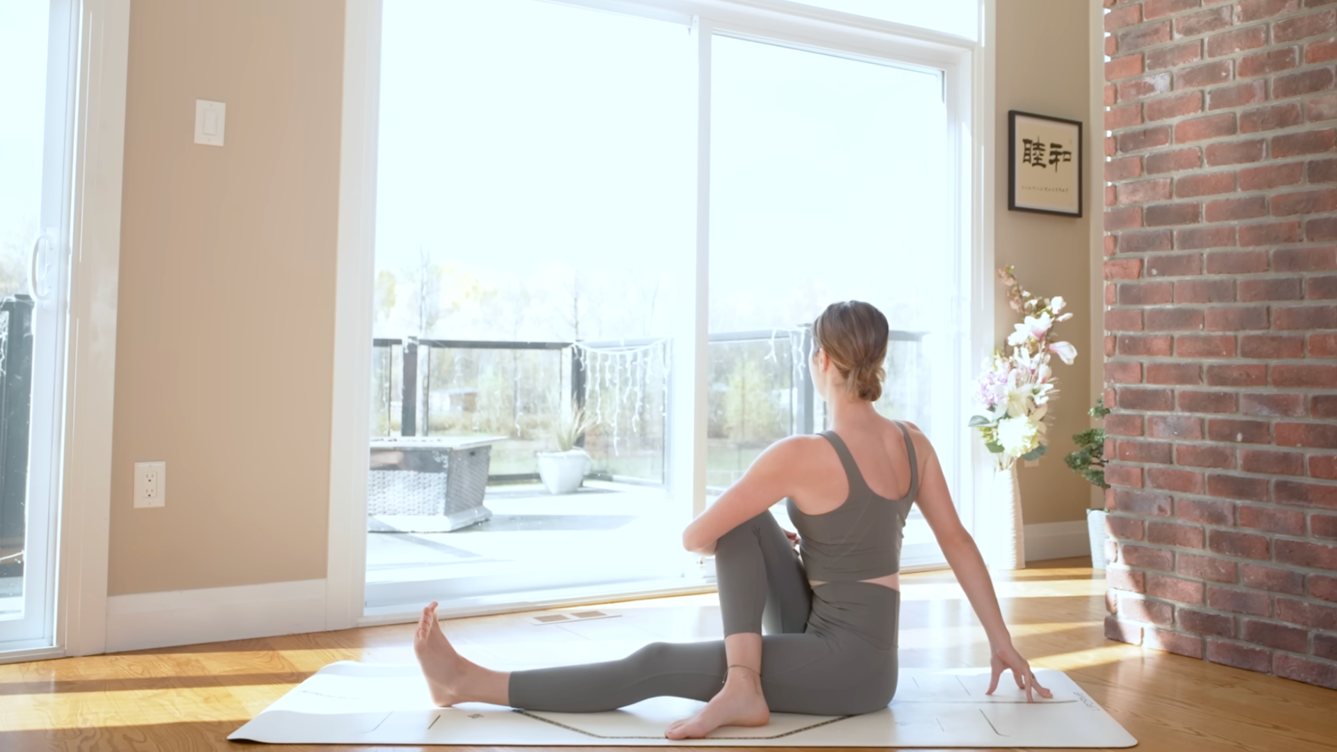 Woman sitting on a mat in a twist during a power yoga for energy practice