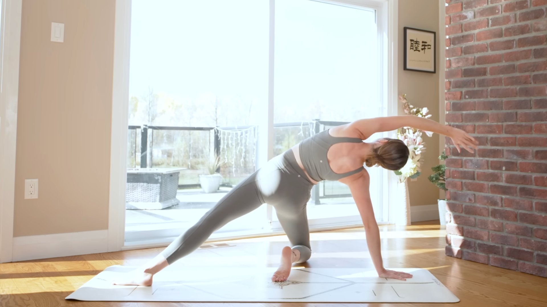 Woman kneeling on a mat in a side stretch and backbend