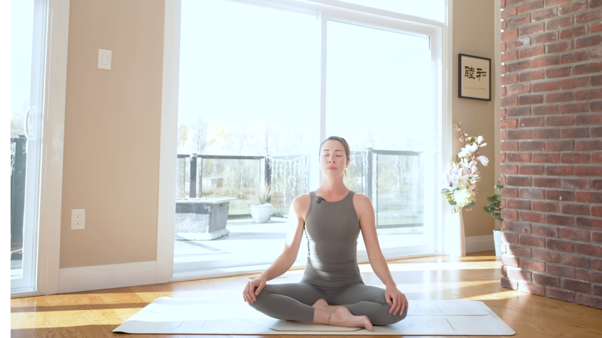 Woman sitting on a mat cross-legged following a power yoga for energy practice