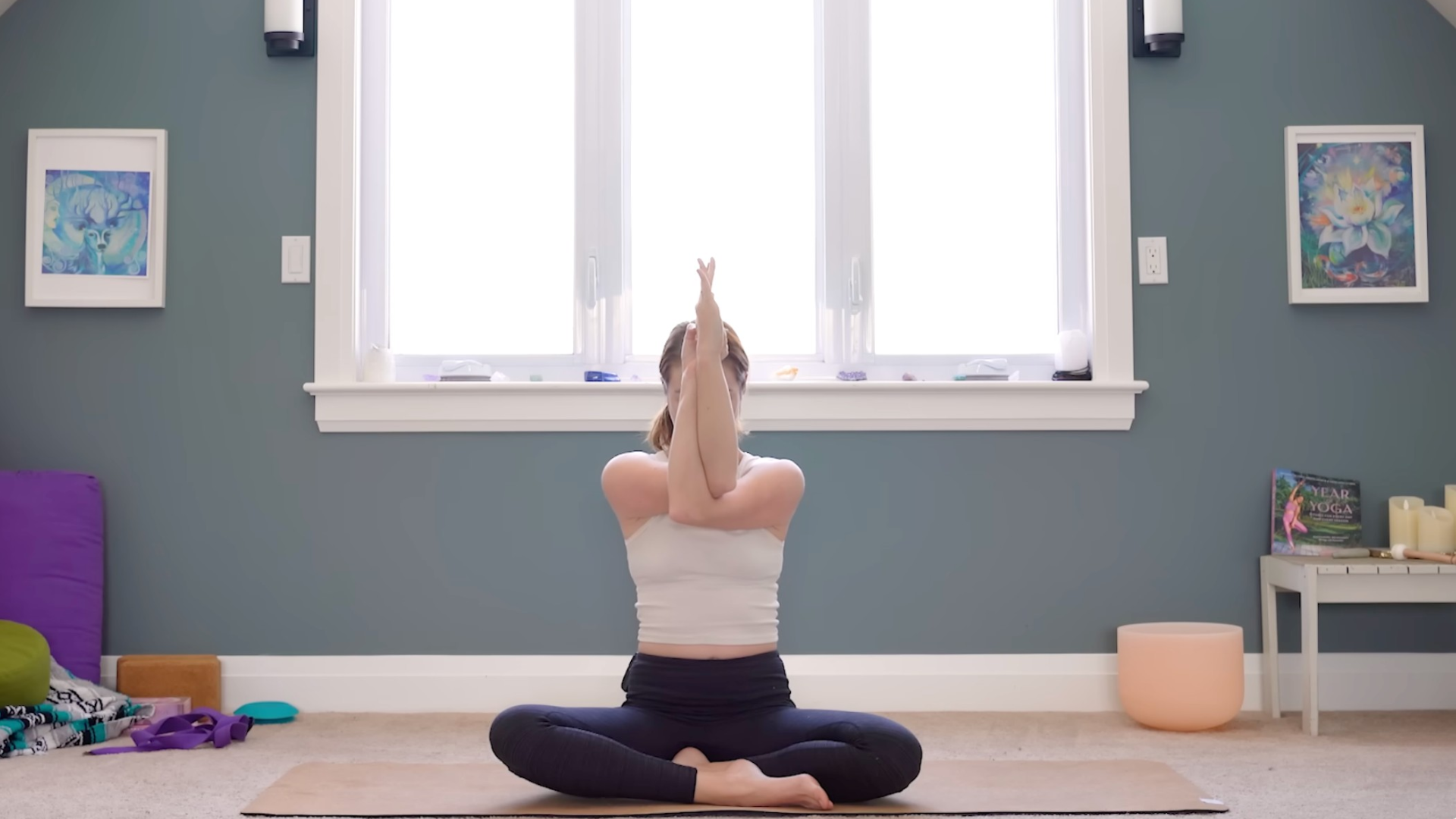 Woman sitting cross-legged practicing shoulder stretches