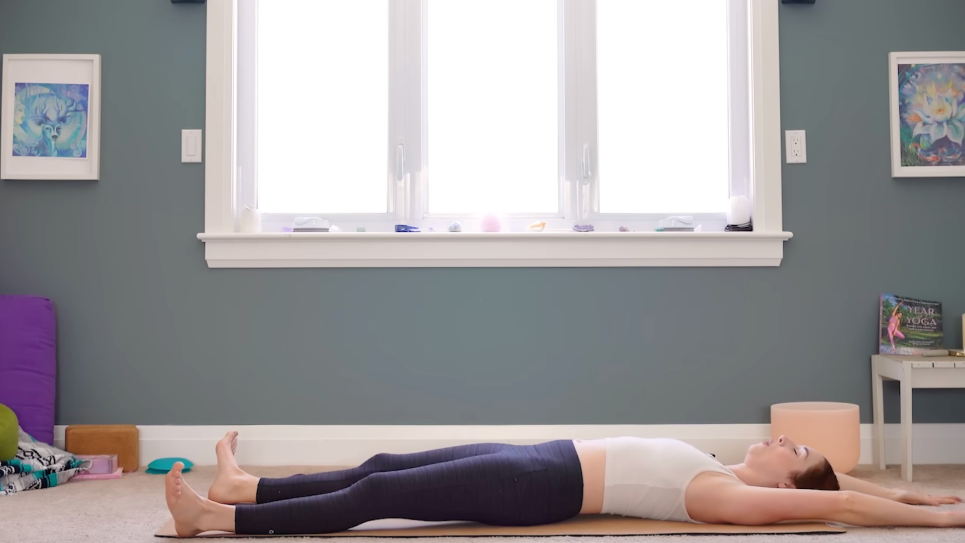 Woman lying on a mat stretching her arms and legs