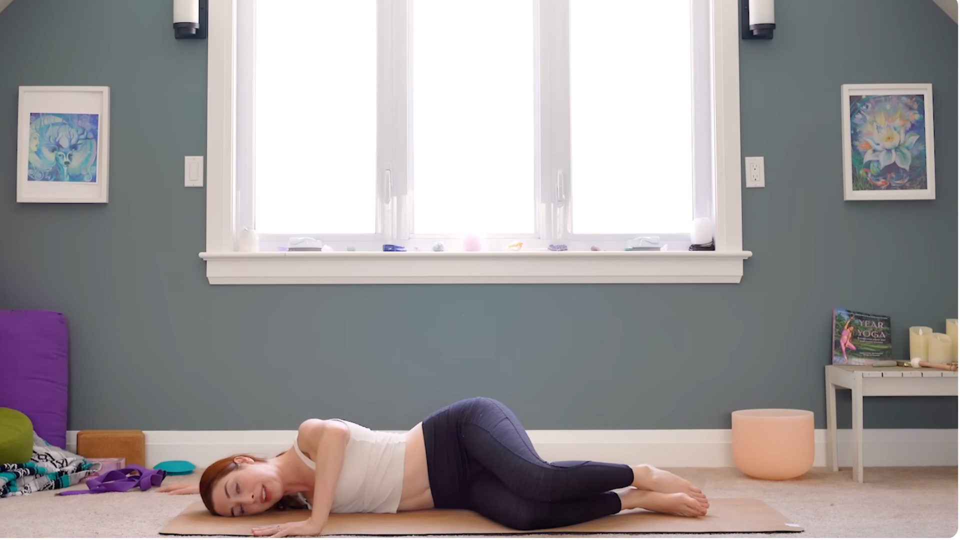 Woman practicing shoulder stretches while lying on her side on a yoga mat