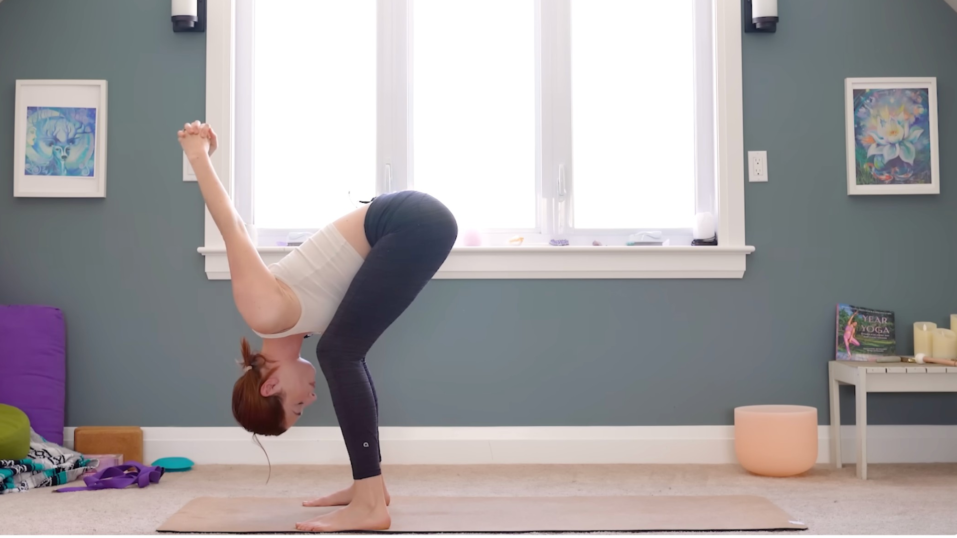 Person standing and leaning forward with arms behind us with her fingers interlaced