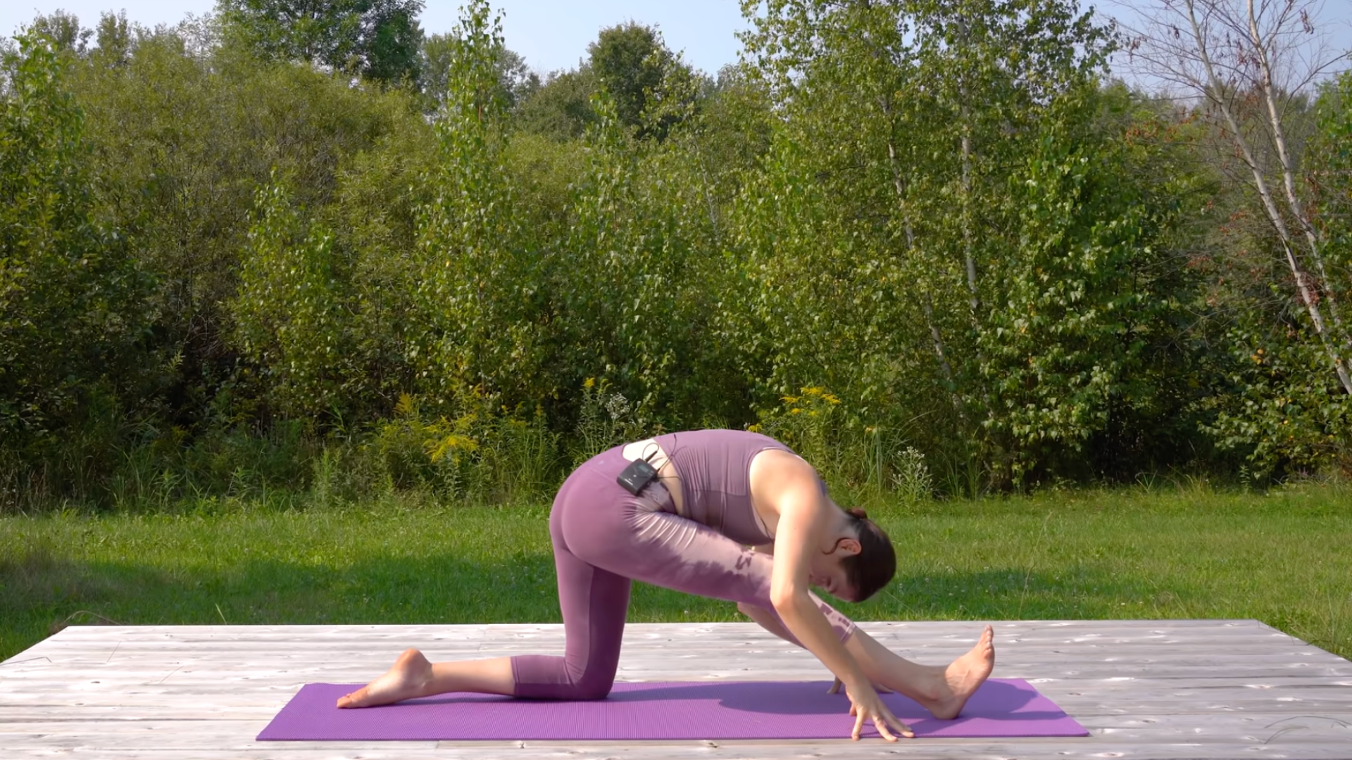 Yoga teacher in Half Splits with her right leg straight while she kneels on her left knee