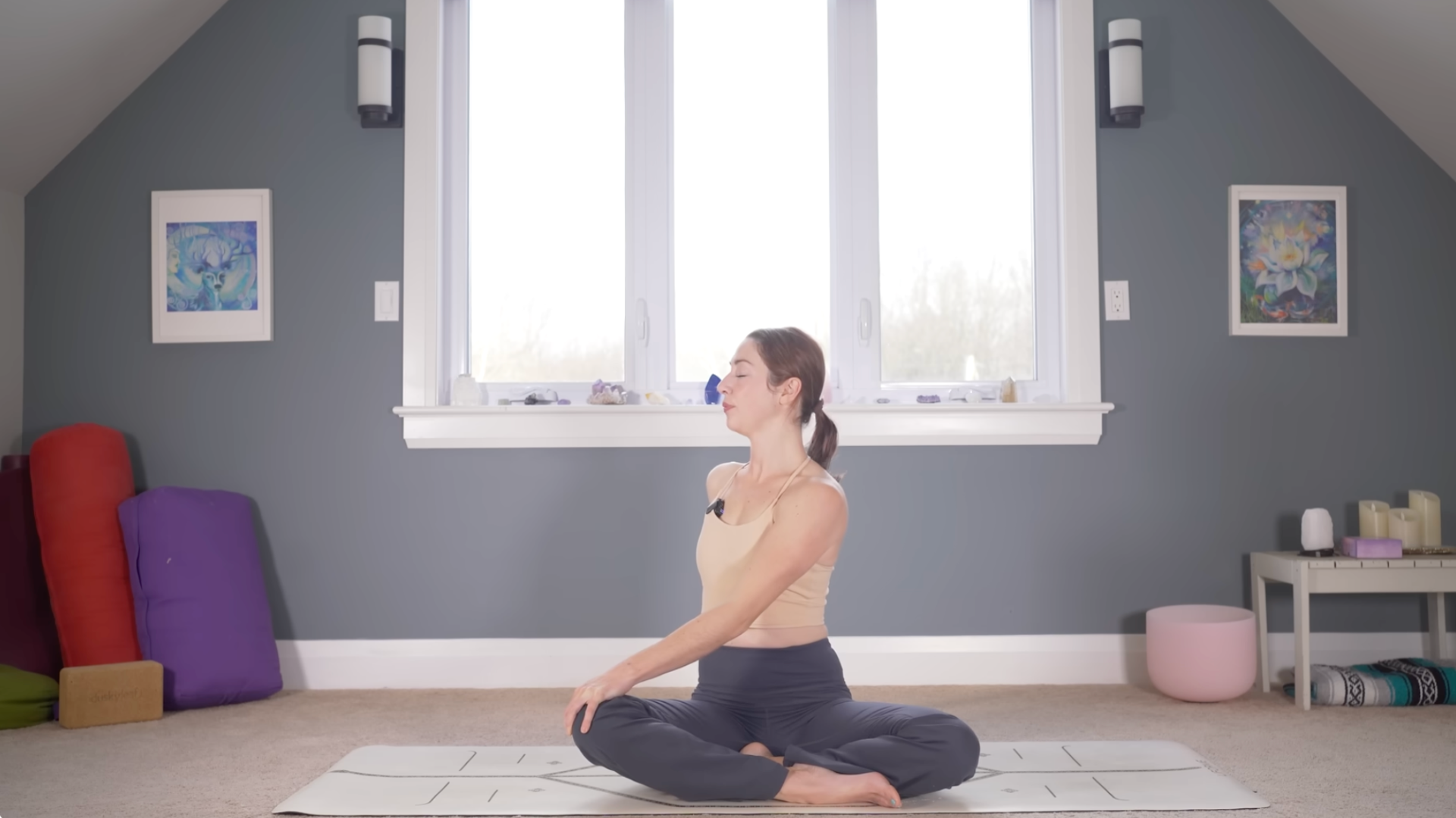Woman sitting cross-legged and twisting to her right in a 10-minute morning yoga practice.